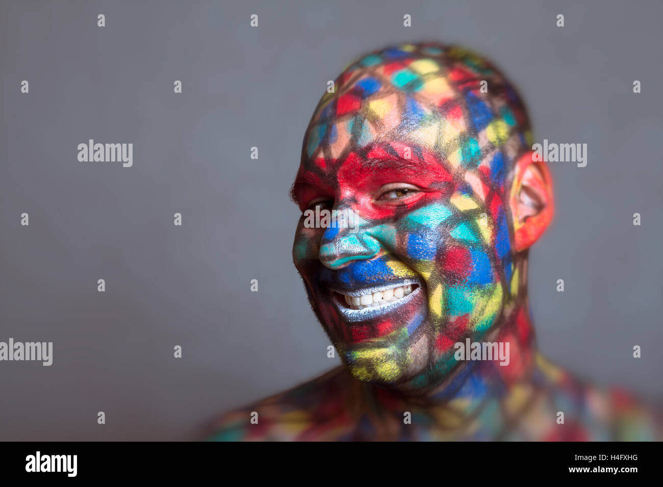 Malicious villain smiling portrait, colorful face art with tilt shift and motion blur effect. Stock Photo