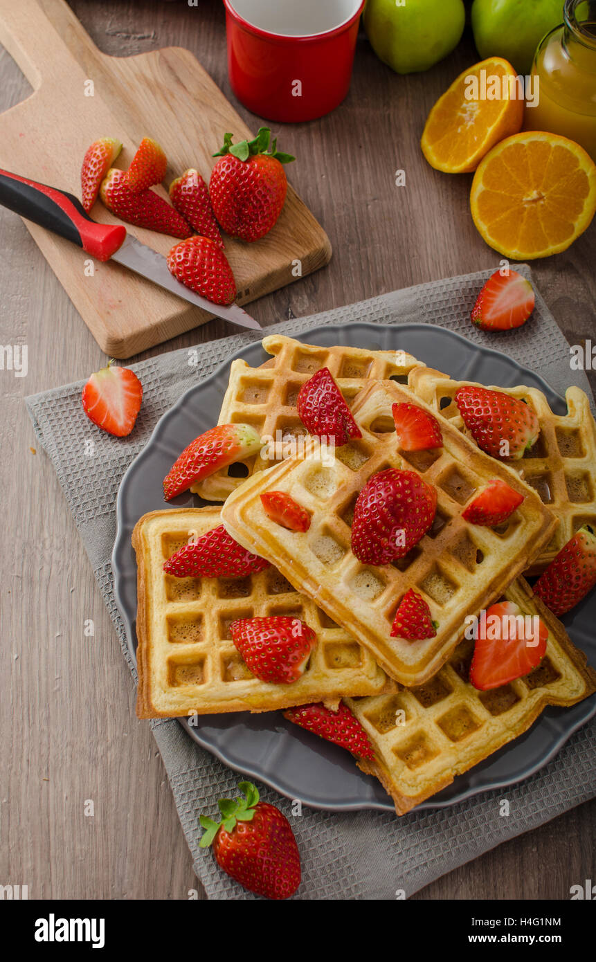 Homemade waffles with maple syrup and strawberries, topped cream and ...