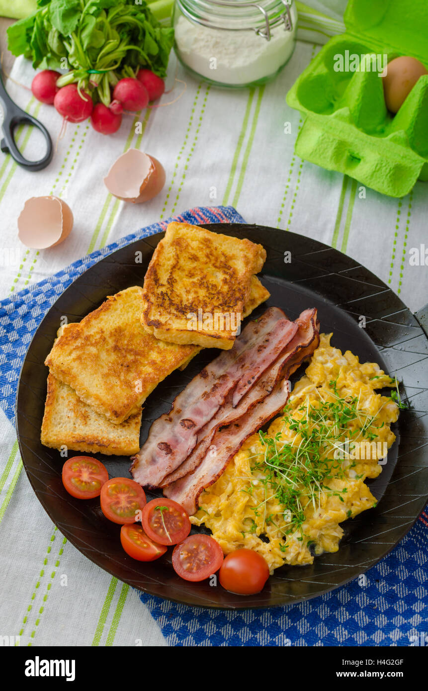 Scrambled Eggs With Bacon And French Toast Tomato And Microgreens Stock Photo Alamy