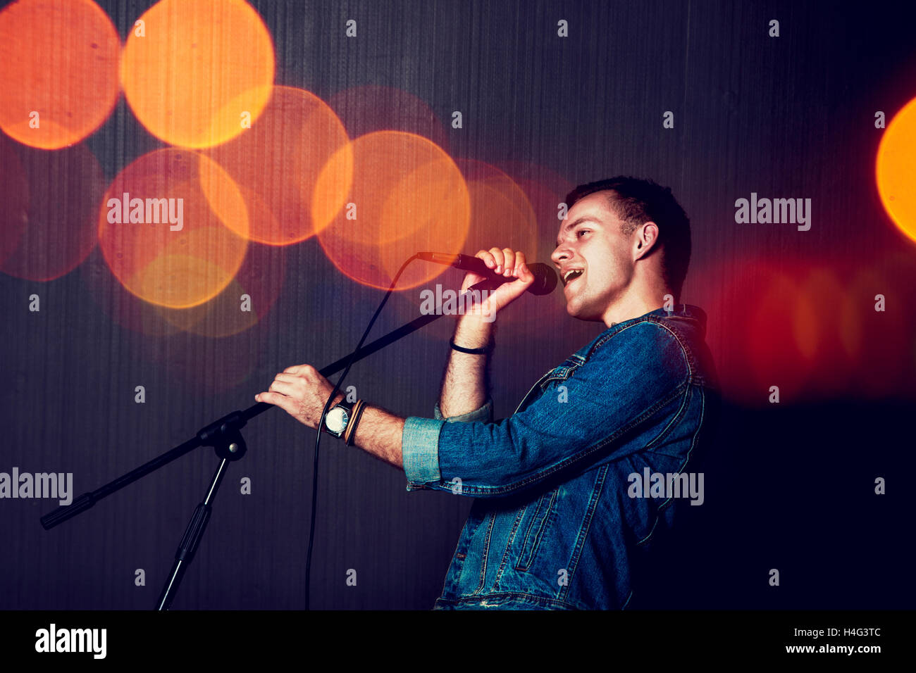 Young Man Singing with Microphone. Stock Photo