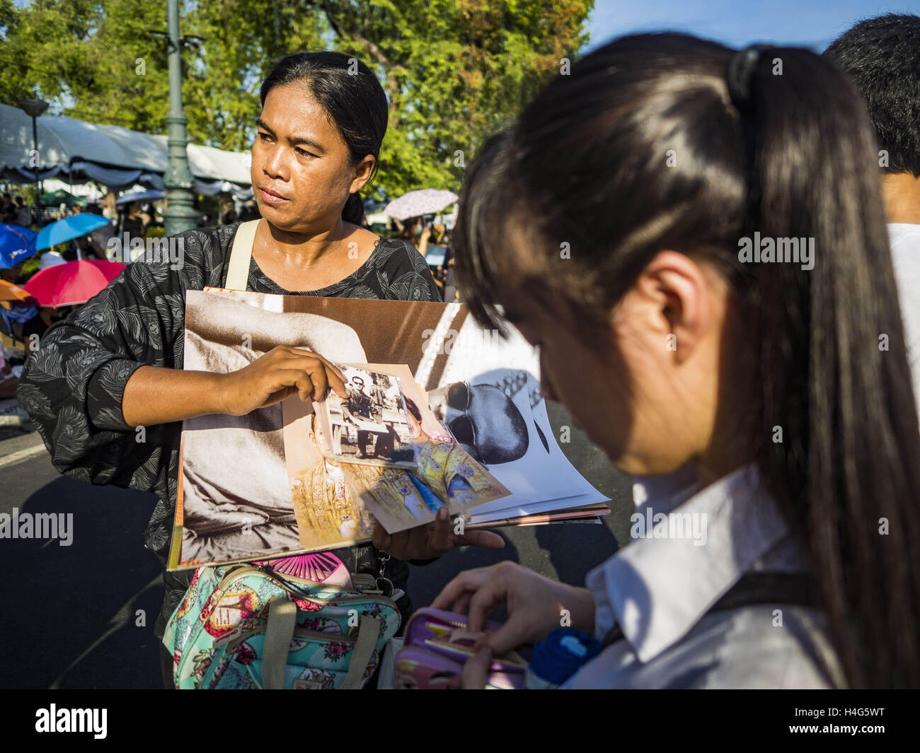 Bangkok, Bangkok, Thailand. 15th Oct, 2016. A woman sells portraits of Bhumibol Adulyadej, the King of Thailand, on a street in front of the Grand Palace in Bangkok. King Bhumibol Adulyadej died Oct. 13, 2016. He was 88. His death comes after a period of failing health. With the king's death, the world's longest-reigning monarch is Queen Elizabeth II, who ascended to the British throne in 1952. Bhumibol Adulyadej, was born in Cambridge, MA, on 5 December 1927. He was the ninth monarch of Thailand from the Chakri Dynasty and is known as Rama IX. He became King on June 9, 1946 and served as Stock Photo