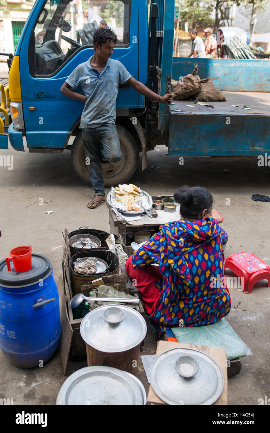 DHAKA, BANGLADESH - OCTOBER 15 : A vendor sell food on street in Dhaka, Bangladesh, on October 15, 2016. Most of time food are being prepared with unhygienic handling. And those food are being sold in open air in a dirty city, which carry many germs. Unhygienic food items that are being sold on the streets of the capital are exposing the consumers to serious health hazards. Thousands of people are taking these foods everyday attracted by their cheap price and fine taste, not knowing what a great danger they are inviting for themselves by eating them.  Some 600 million people fall ill each year Stock Photo