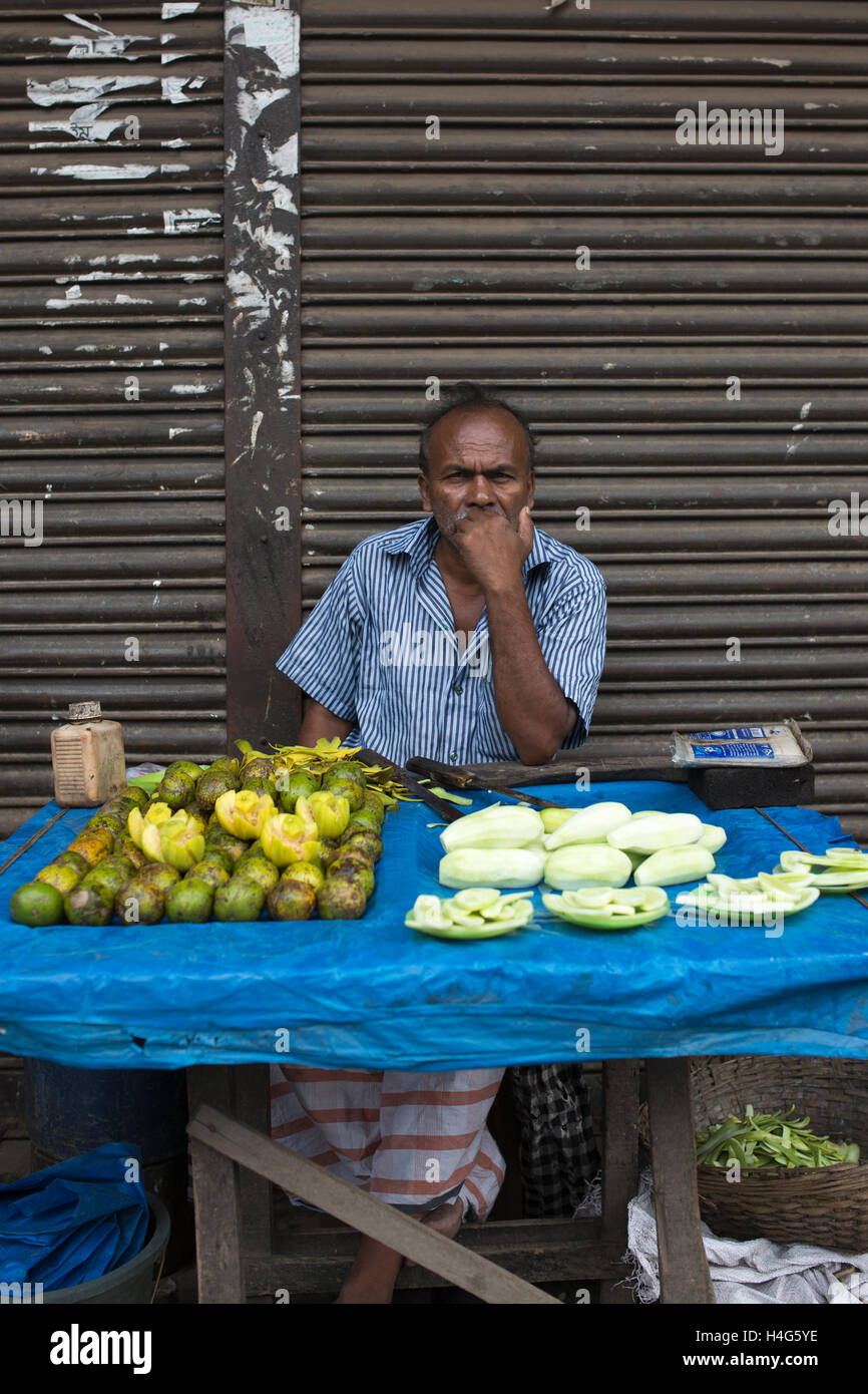 DHAKA, BANGLADESH - OCTOBER 15 : A vendor sell food on street in Dhaka, Bangladesh, on October 15, 2016. Most of time food are being prepared with unhygienic handling. And those food are being sold in open air in a dirty city, which carry many germs. Unhygienic food items that are being sold on the streets of the capital are exposing the consumers to serious health hazards. Thousands of people are taking these foods everyday attracted by their cheap price and fine taste, not knowing what a great danger they are inviting for themselves by eating them.  Some 600 million people fall ill each year Stock Photo