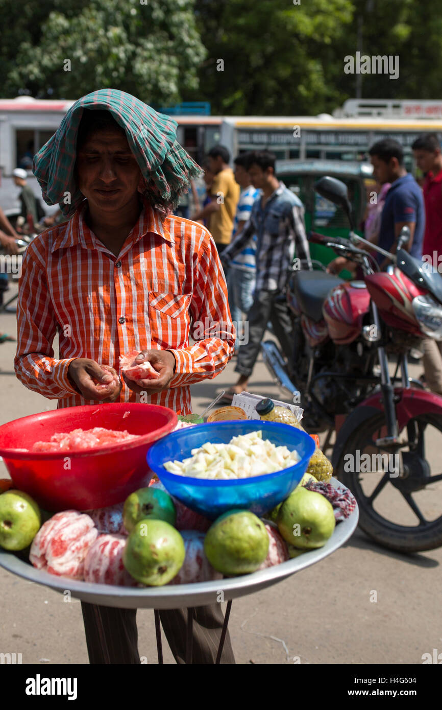 DHAKA, BANGLADESH - OCTOBER 15 : A vendor sell food on street in Dhaka, Bangladesh, on October 15, 2016. Most of time food are being prepared with unhygienic handling. And those food are being sold in open air in a dirty city, which carry many germs. Unhygienic food items that are being sold on the streets of the capital are exposing the consumers to serious health hazards. Thousands of people are taking these foods everyday attracted by their cheap price and fine taste, not knowing what a great danger they are inviting for themselves by eating them.  Some 600 million people fall ill each year Stock Photo