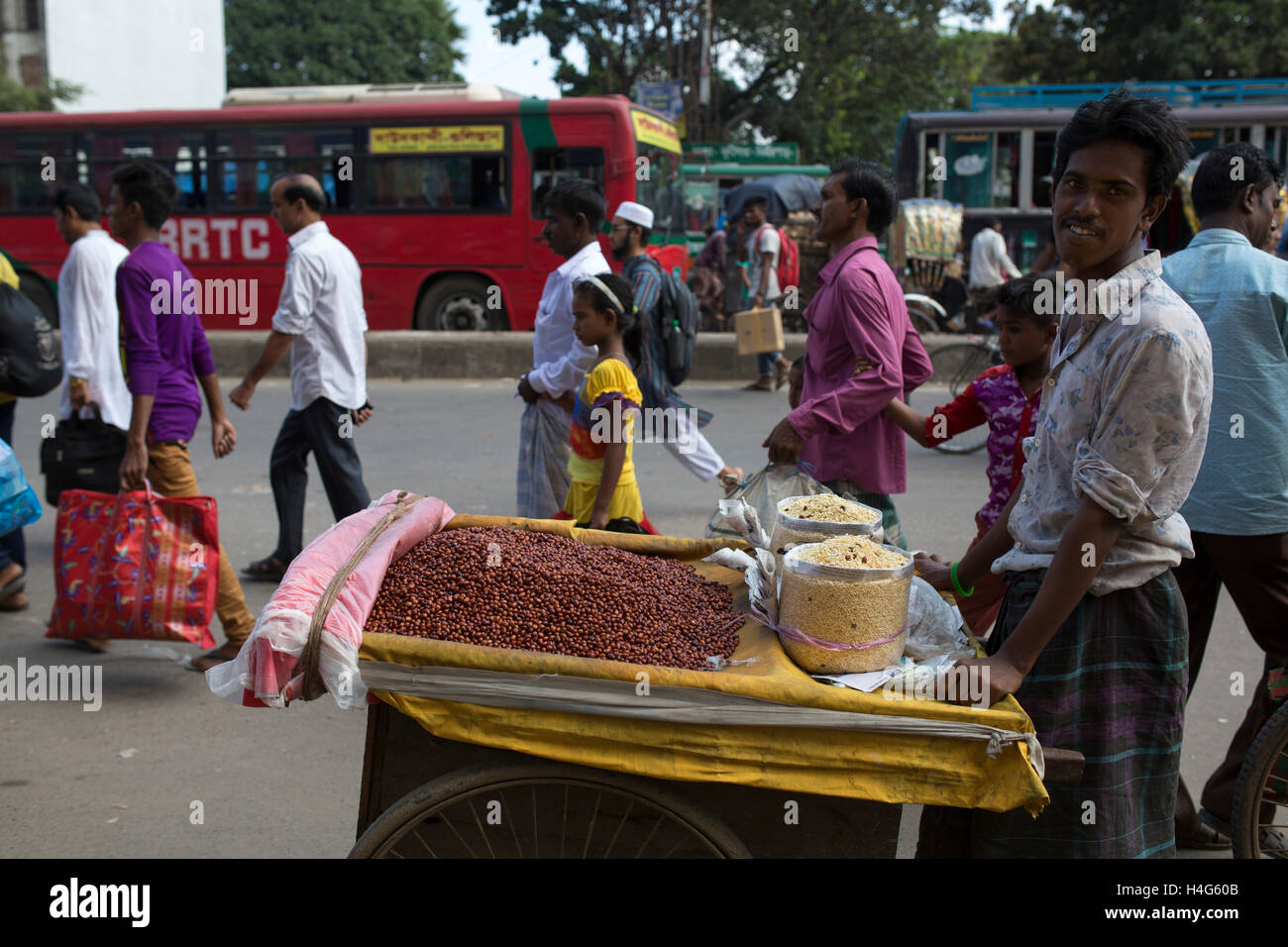 DHAKA, BANGLADESH - OCTOBER 15 : A vendor sell food on street in Dhaka, Bangladesh, on October 15, 2016. Most of time food are being prepared with unhygienic handling. And those food are being sold in open air in a dirty city, which carry many germs. Unhygienic food items that are being sold on the streets of the capital are exposing the consumers to serious health hazards. Thousands of people are taking these foods everyday attracted by their cheap price and fine taste, not knowing what a great danger they are inviting for themselves by eating them.  Some 600 million people fall ill each year Stock Photo