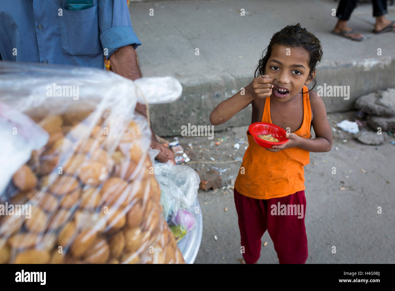 Dhaka, Bangladesh. 15th October, 2016. A child eating street food in Dhaka, Bangladesh, on October 15, 2016. Most of time food are being prepared with unhygienic handling. And those food are being sold in open air in a dirty city, which carry many germs. Unhygienic food items that are being sold on the streets of the capital are exposing the consumers to serious health hazards. Credit:  zakir hossain chowdhury zakir/Alamy Live News Stock Photo