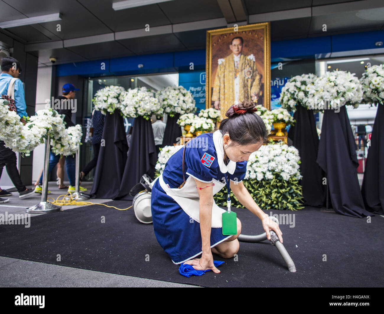 Bangkok, Bangkok, Thailand. 16th Oct, 2016. A worker cleans the carpet in front of a shrine for Thai King Bhumibol Adulyadej who died Oct. 13, 2016. He was 88. His death comes after a period of failing health. With the king's death, the world's longest-reigning monarch is Queen Elizabeth II, who ascended to the British throne in 1952. Bhumibol Adulyadej, was born in Cambridge, MA, on 5 December 1927. He was the ninth monarch of Thailand from the Chakri Dynasty and is known as Rama IX. He became King on June 9, 1946 and served as King of Thailand for 70 years, 126 days. He was, at the time Stock Photo