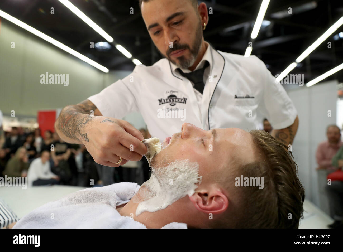 Nuremberg, Germany. 16th Oct, 2016. Guiseppe Rizza, participant at the German Barber Awards 2016, works on a Businesslook Cut and Shave on a model in Nuremberg, Germany, 16 October 2016. PHOTO: DANIEL KARMANN/dpa/Alamy Live News Stock Photo