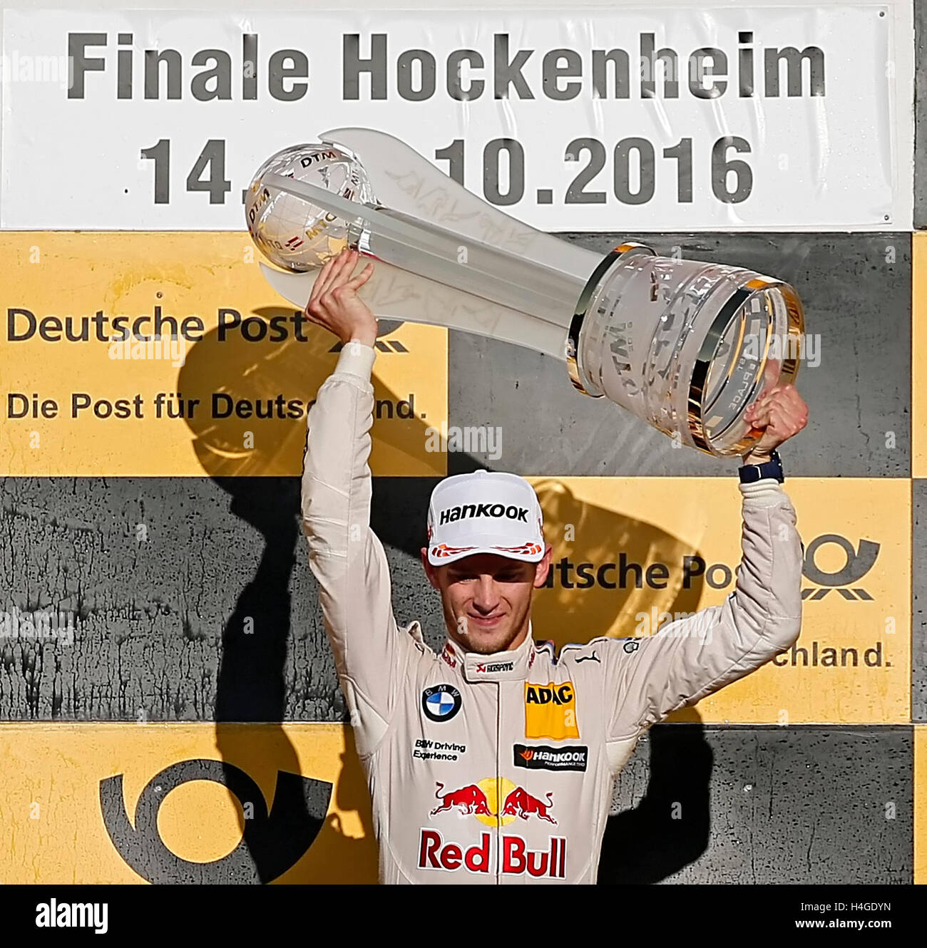 German race driver Marco Wittmann stands on the podium holding the cup ...