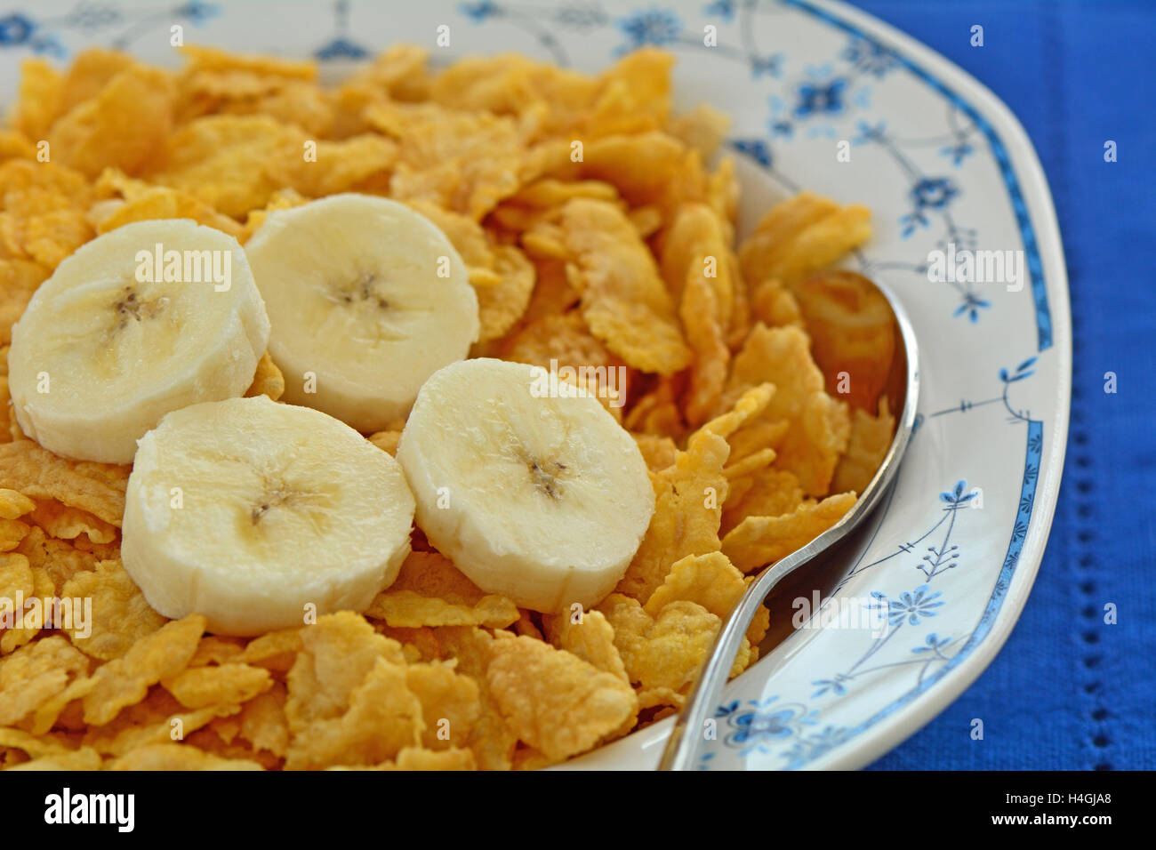 Crisp golden organic corn flakes with banana slices in pretty blue and
