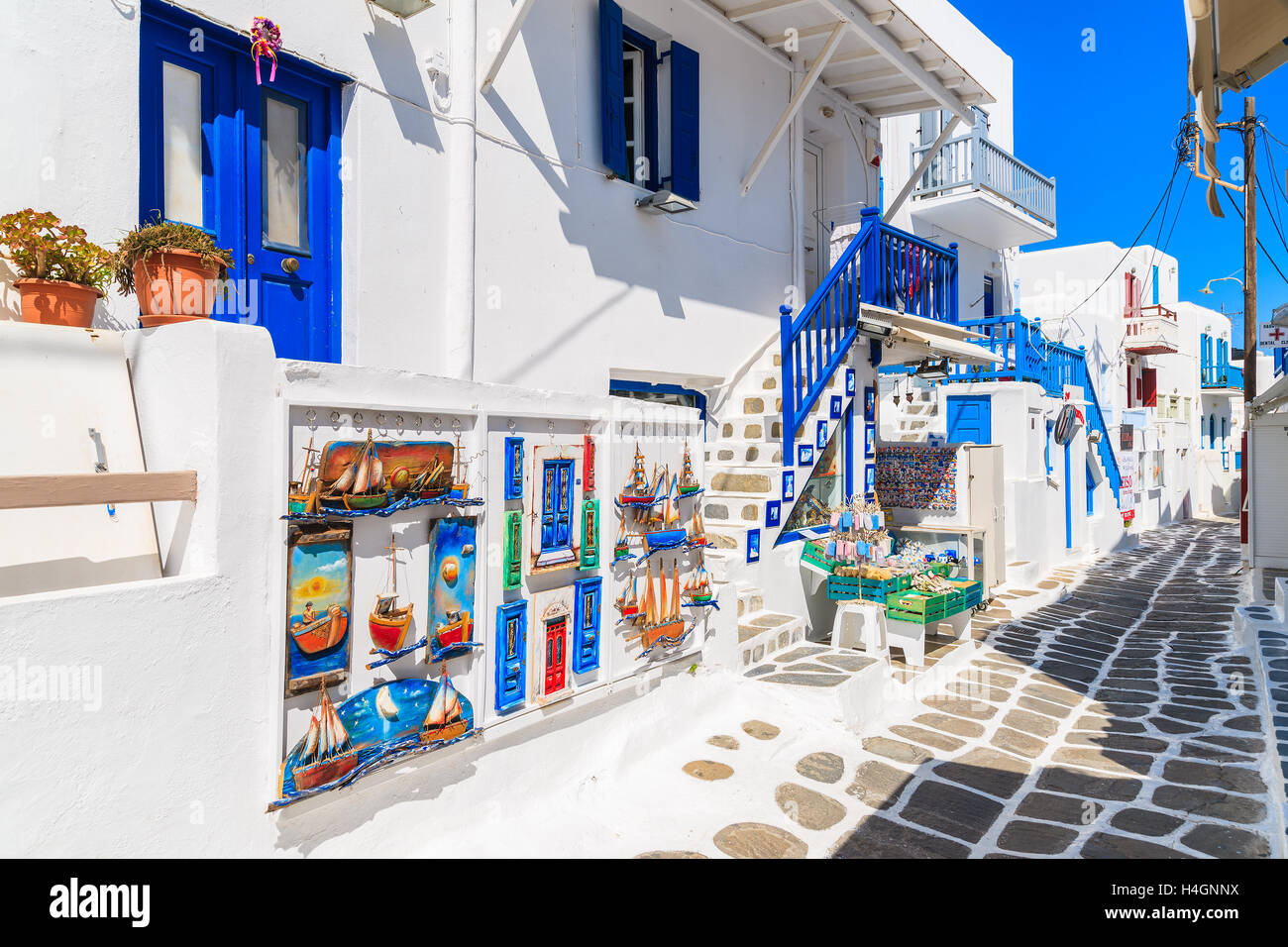 MYKONOS TOWN, GREECE - MAY 16, 2016: shop with typical for Greek islands souvenirs on whitewashed street in beautiful Mykonos to Stock Photo