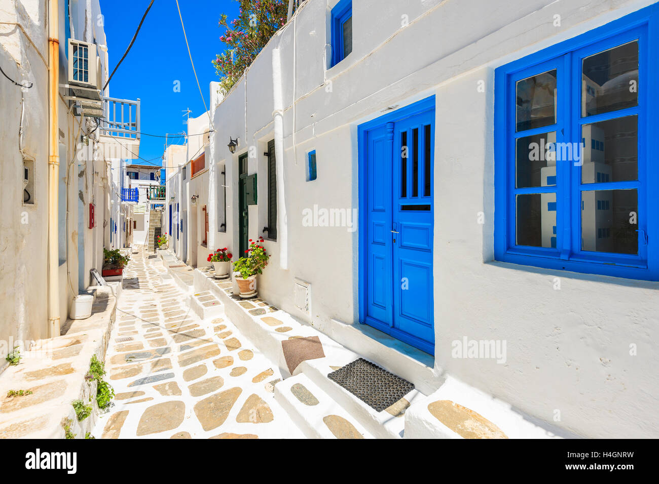 Typical white Greek houses with blue doors and windows on street of