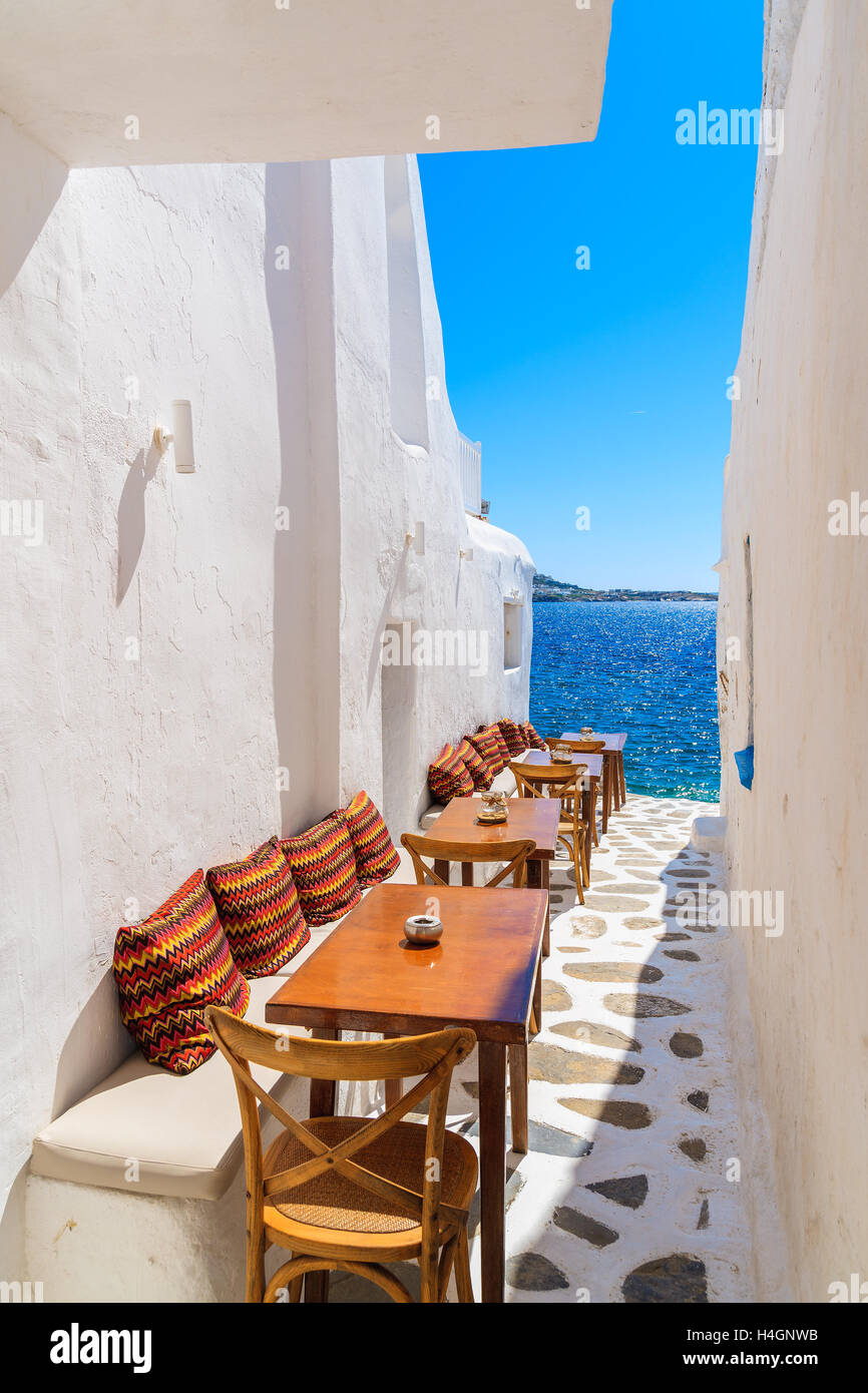 Benches with pillows in a typical Greek bar in Mykonos town with sea view, Cyclades islands, Greece Stock Photo