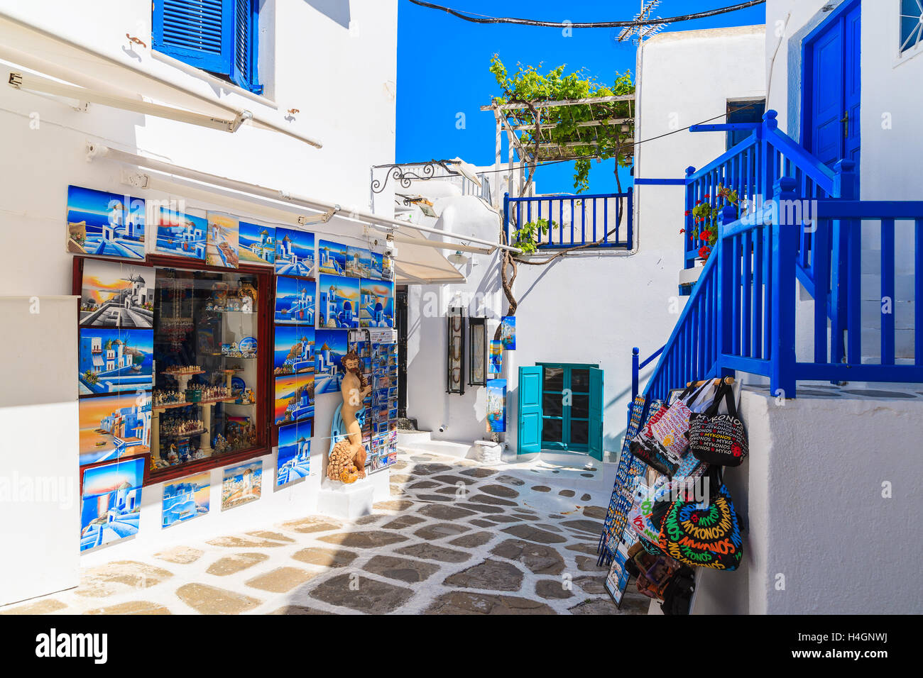 MYKONOS TOWN, GREECE - MAY 16, 2016: shop with typical for Greek islands paintings and souvenirs on whitewashed street in beauti Stock Photo