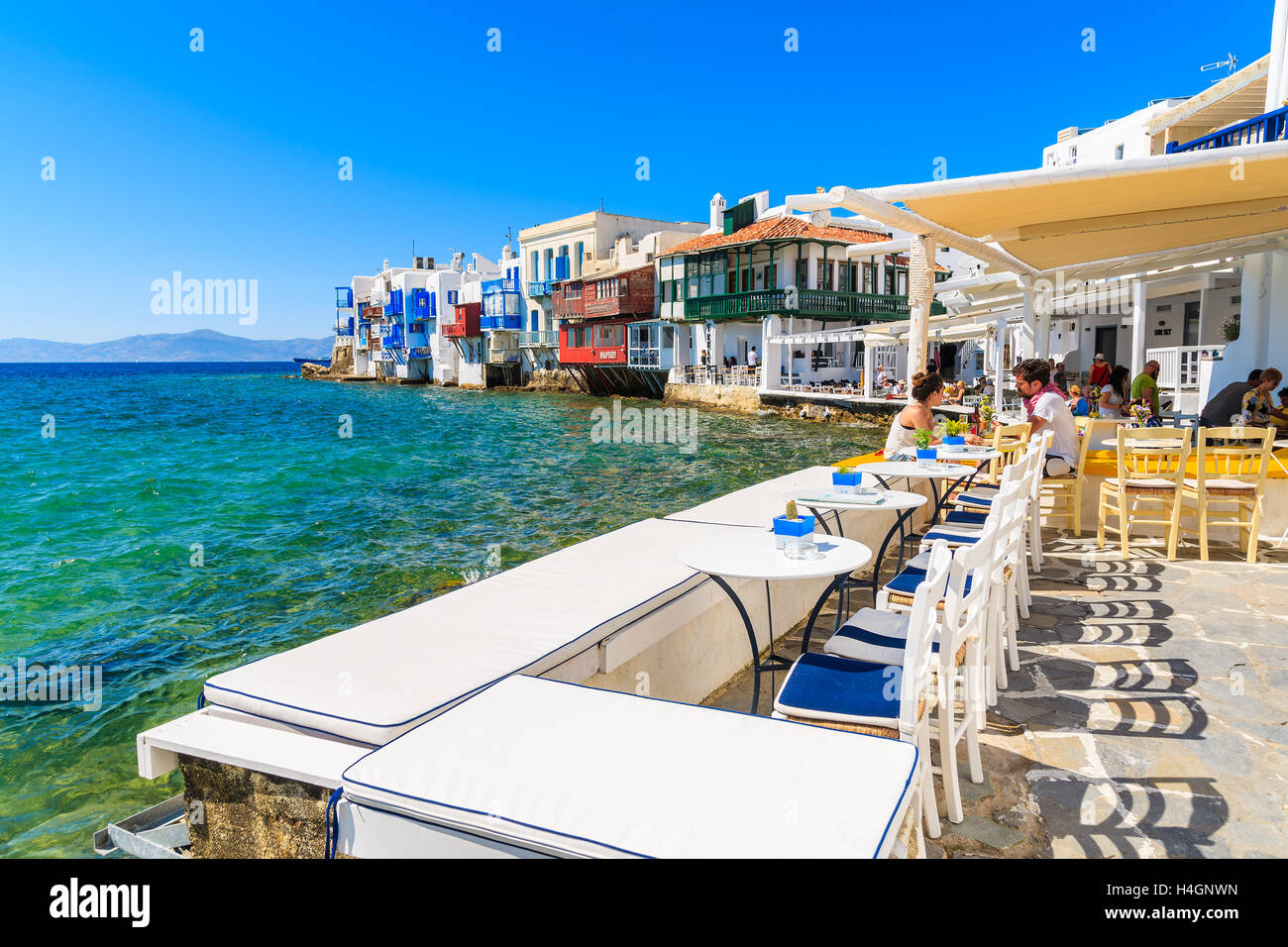 LITTLE VENICE, MYKONOS ISLAND - MAY 16, 2016: people dining in typical Greek tavern in Little Venice part of Mykonos town, Mykon Stock Photo