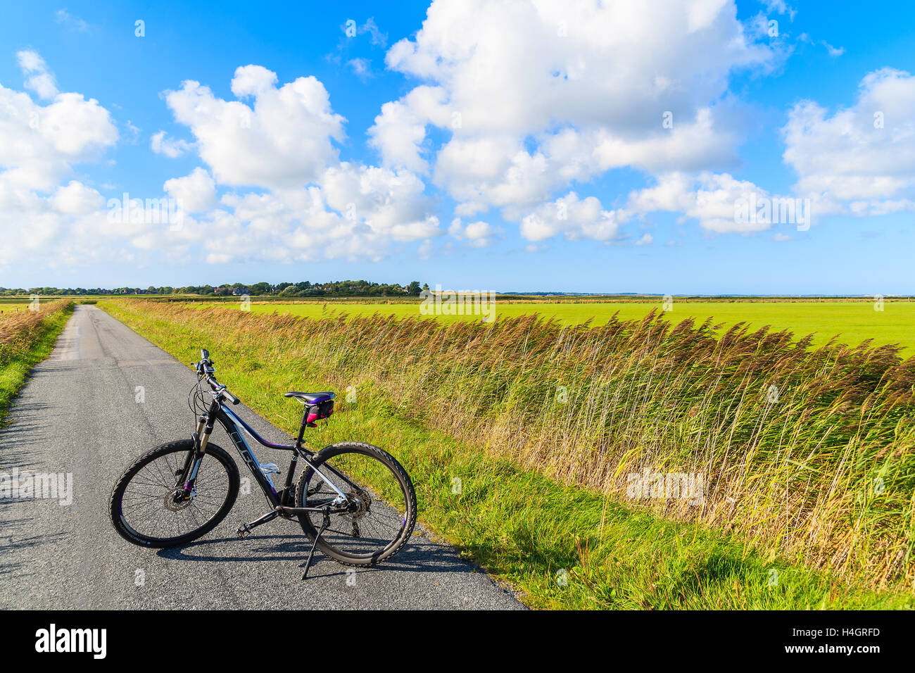 SYLT ISLAND, GERMANY - SEP 9, 2016: bike on road in green countryside landscape of Sylt island near Keitum village, Germany. Stock Photo