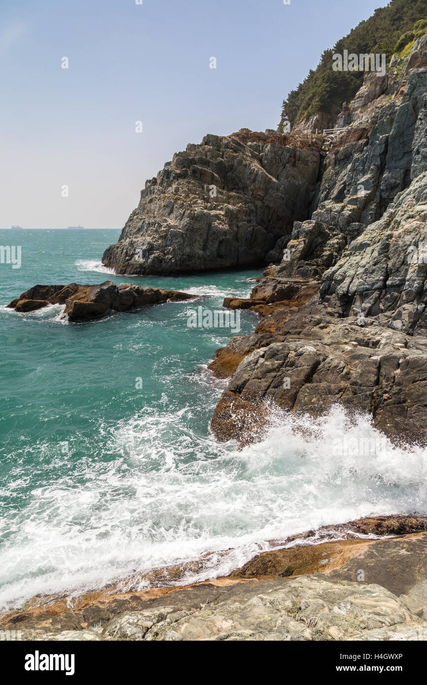 View of wave breaking, ocean, and rocky and rugged cliff at the ...