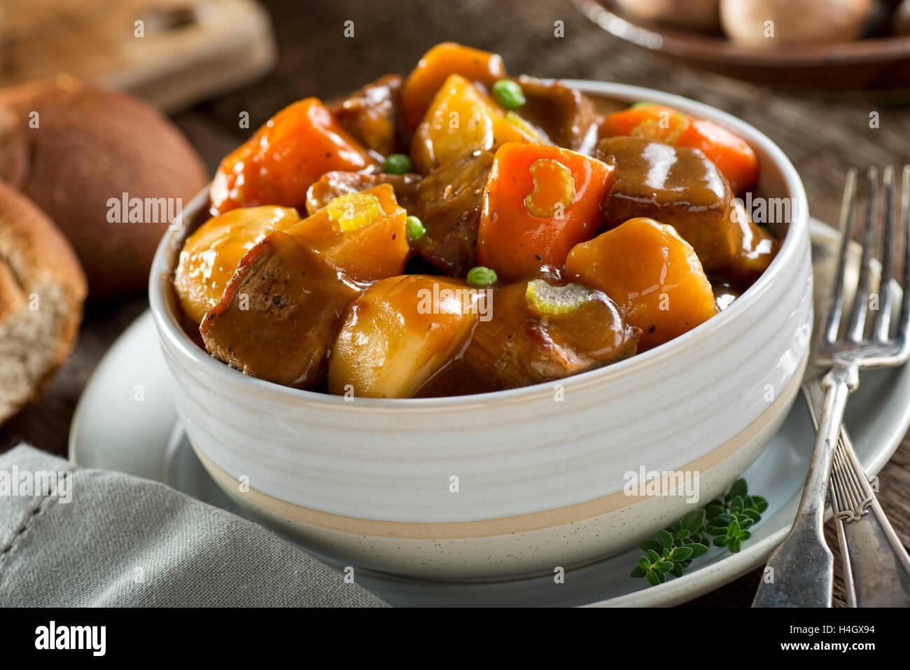 A delicious bowl of rich and hearty beef stew with potato, turnip, carrot, celery, and peas. Stock Photo