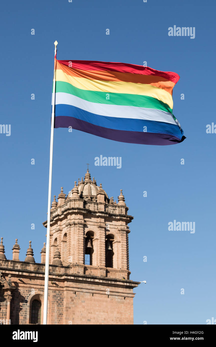 Incan rainbow flag flying proudly in the Plaza de Armas over the Templo de la Compañía de Jesús in Cusco, Peru Stock Photo