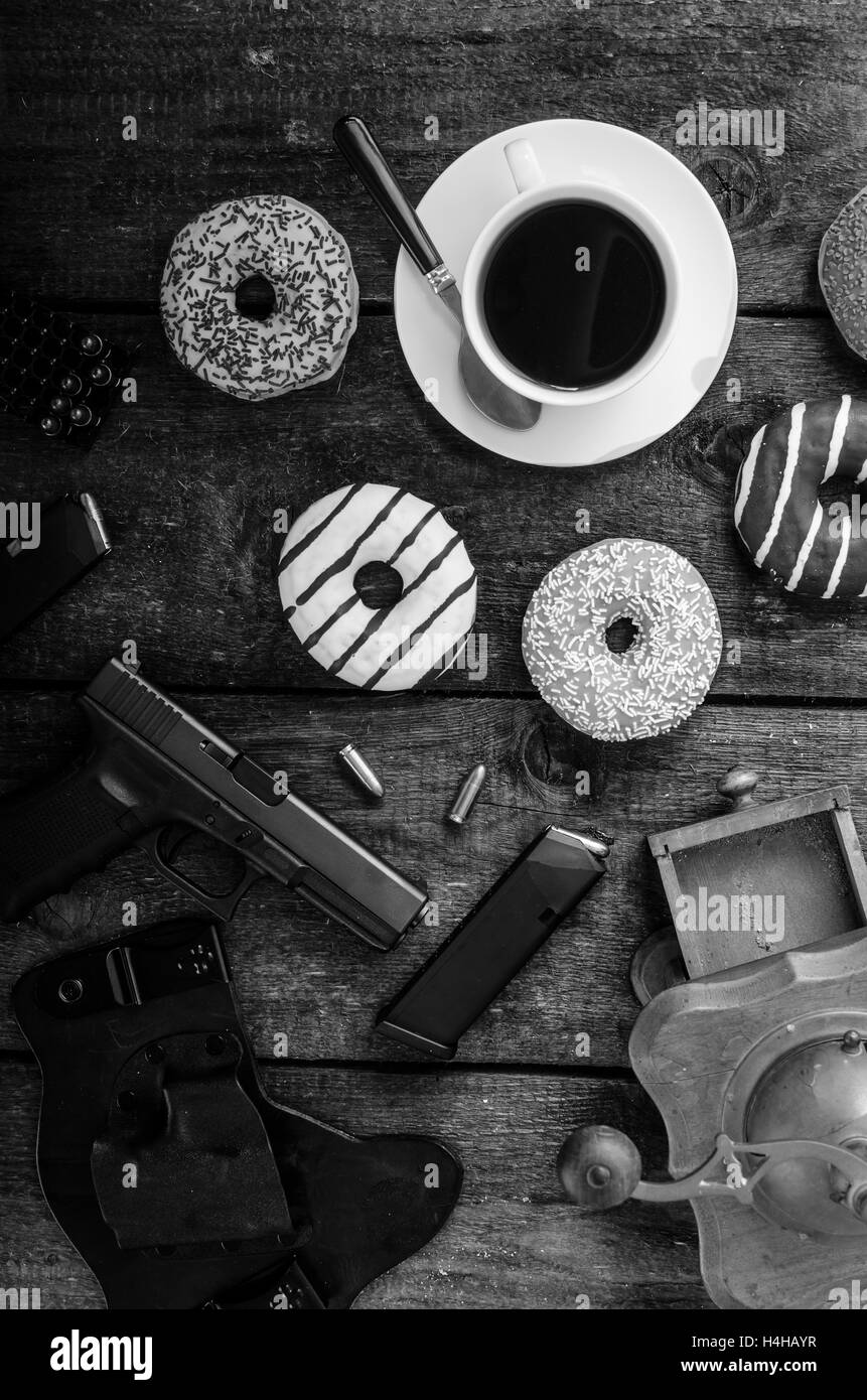 American police officer morning, donuts, juice, fresh black coffee and his gun Stock Photo