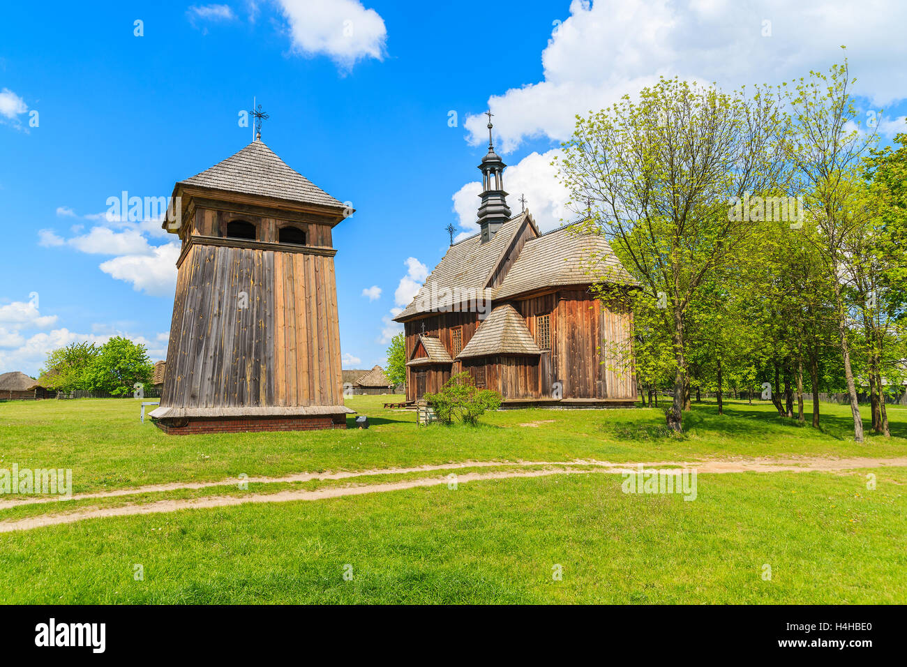 Old wooden church on green meadow in Tokarnia village, Poland Stock Photo