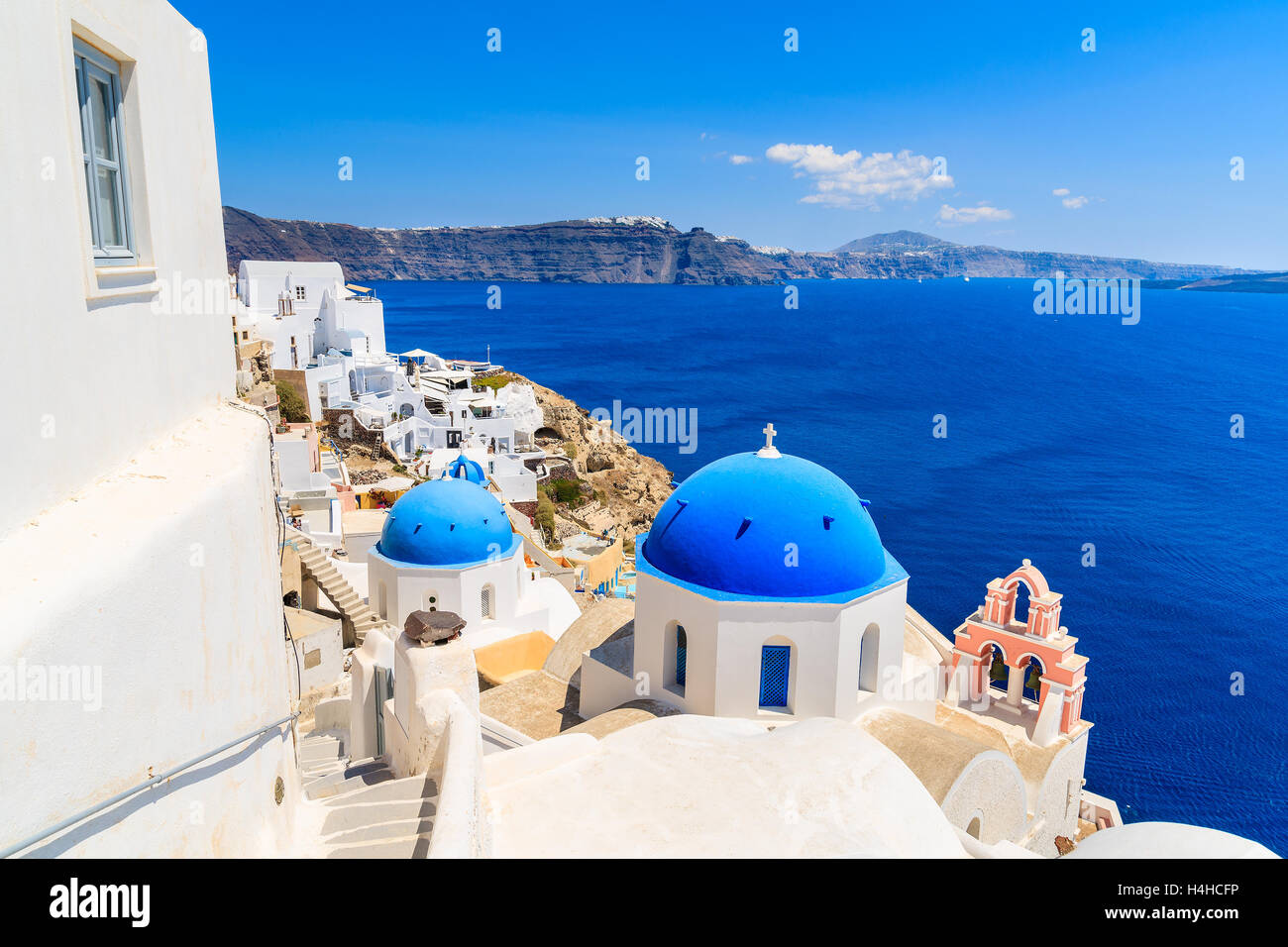 Famous blue dome of a church in Oia village and view of blue sea with caldera on Santorini island, Greece Stock Photo
