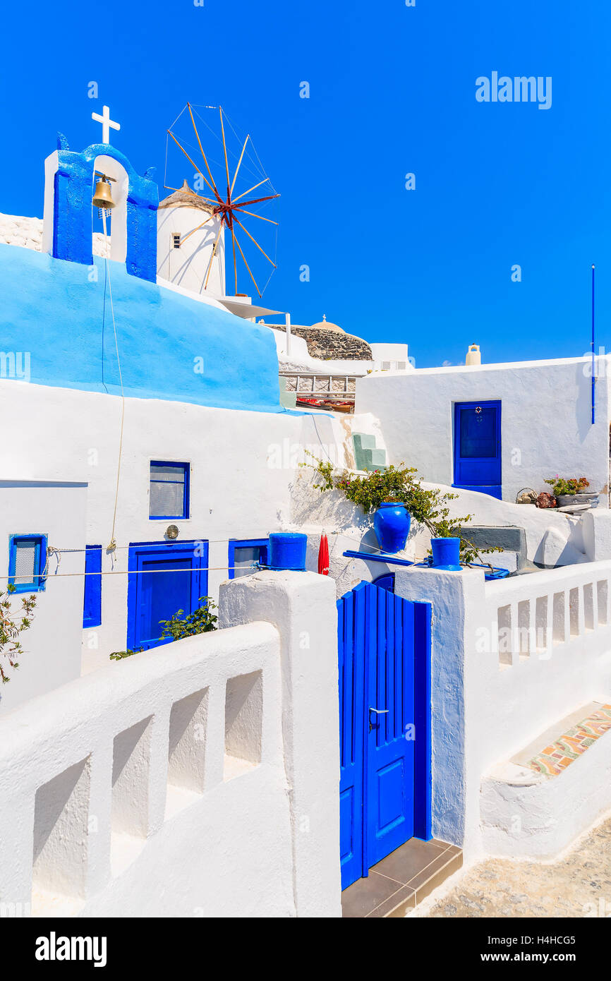 Typical Greek houses and windmill on street of Oia village, Santorini island, Greece Stock Photo