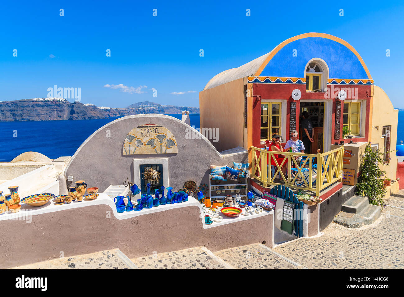 OIA VILLAGE, SANTORINI ISLAND - MAY 23, 2016: Typical Greek shops with souvenirs and small restaurant on street of Oia village,  Stock Photo