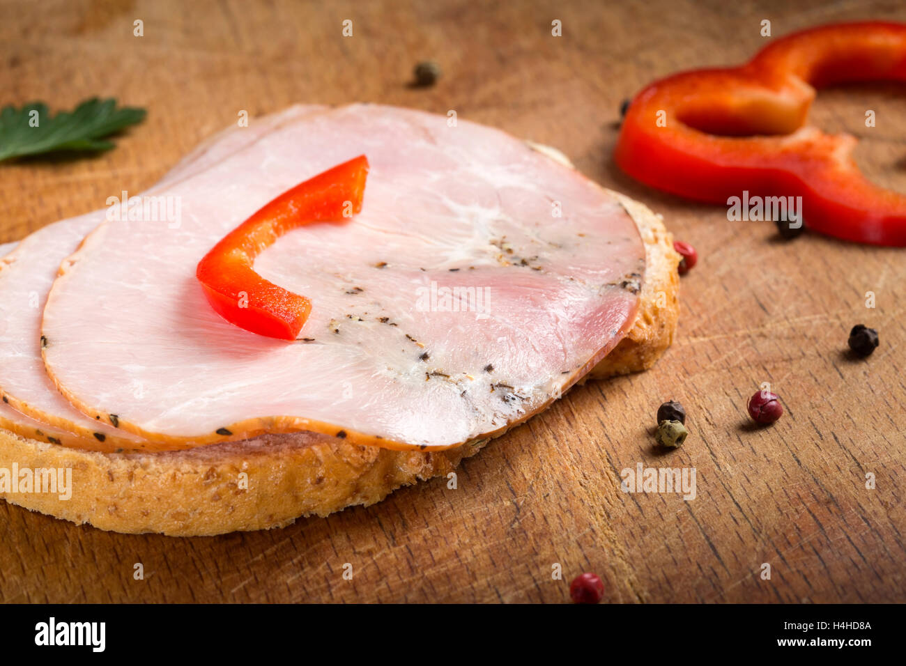 Open sandwich made with ham pepper on wooden background Stock Photo