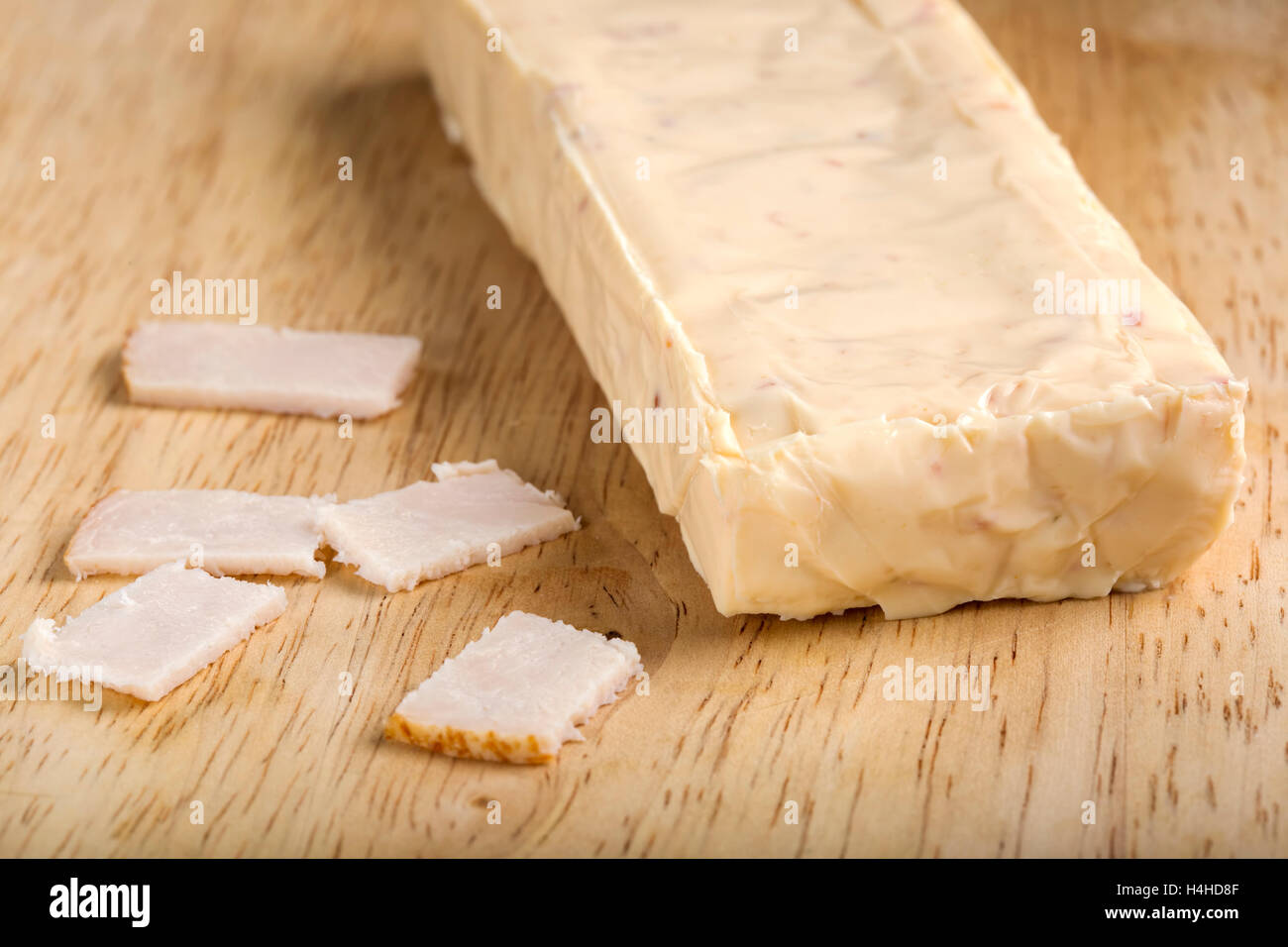 Block of melted cheese with ham over wooden background Stock Photo