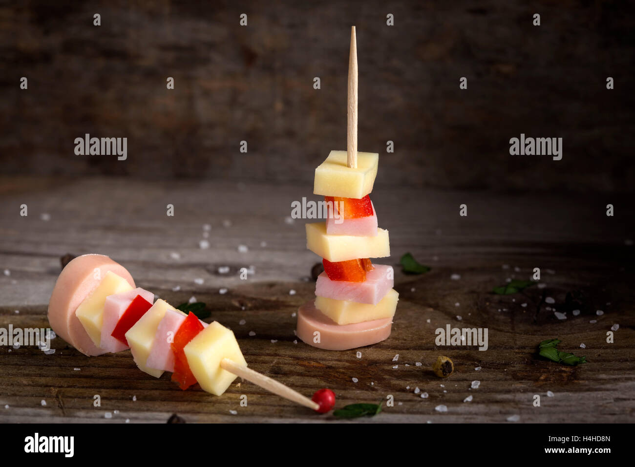 Ham, cheese and red pepper appetizer with spices over wooden background Stock Photo