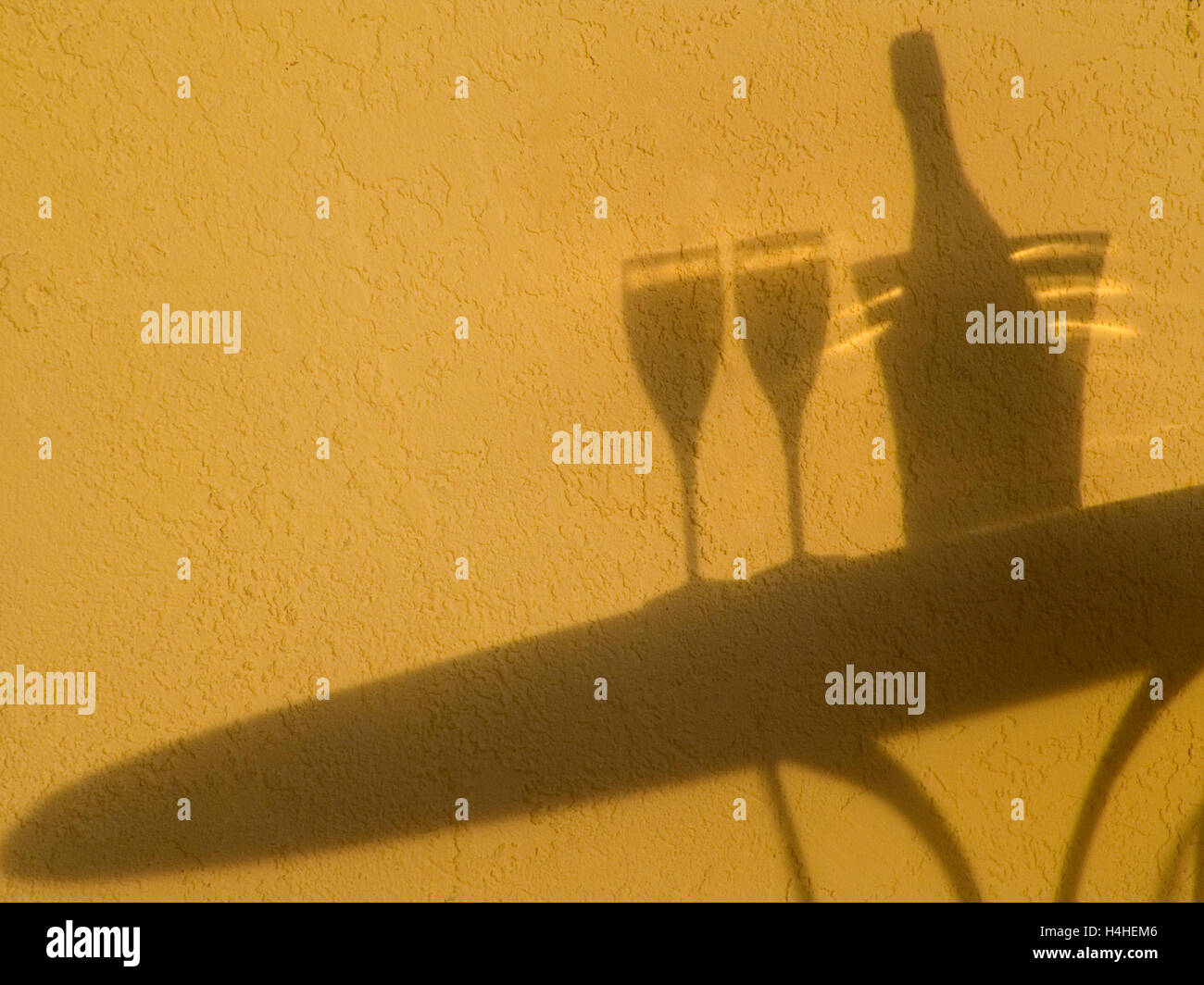 CHAMPAGNE RETRO LIFESTYLE HOLIDAY VACATION Shadow silhouette of sparkling Champagne wine bottle, ice bucket and two glasses on alfresco terrace table at sunset Stock Photo