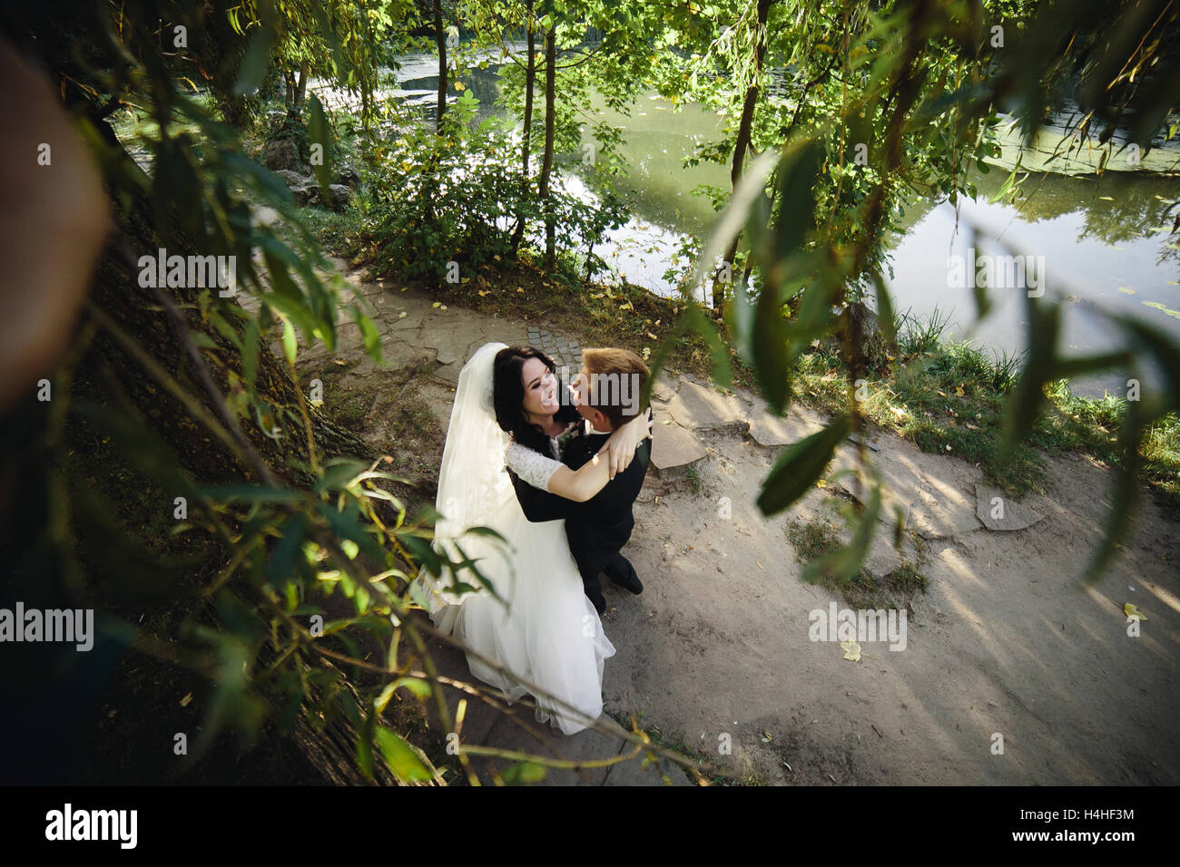 Beautiful wedding couple hugging in the park Stock Photo - Alamy