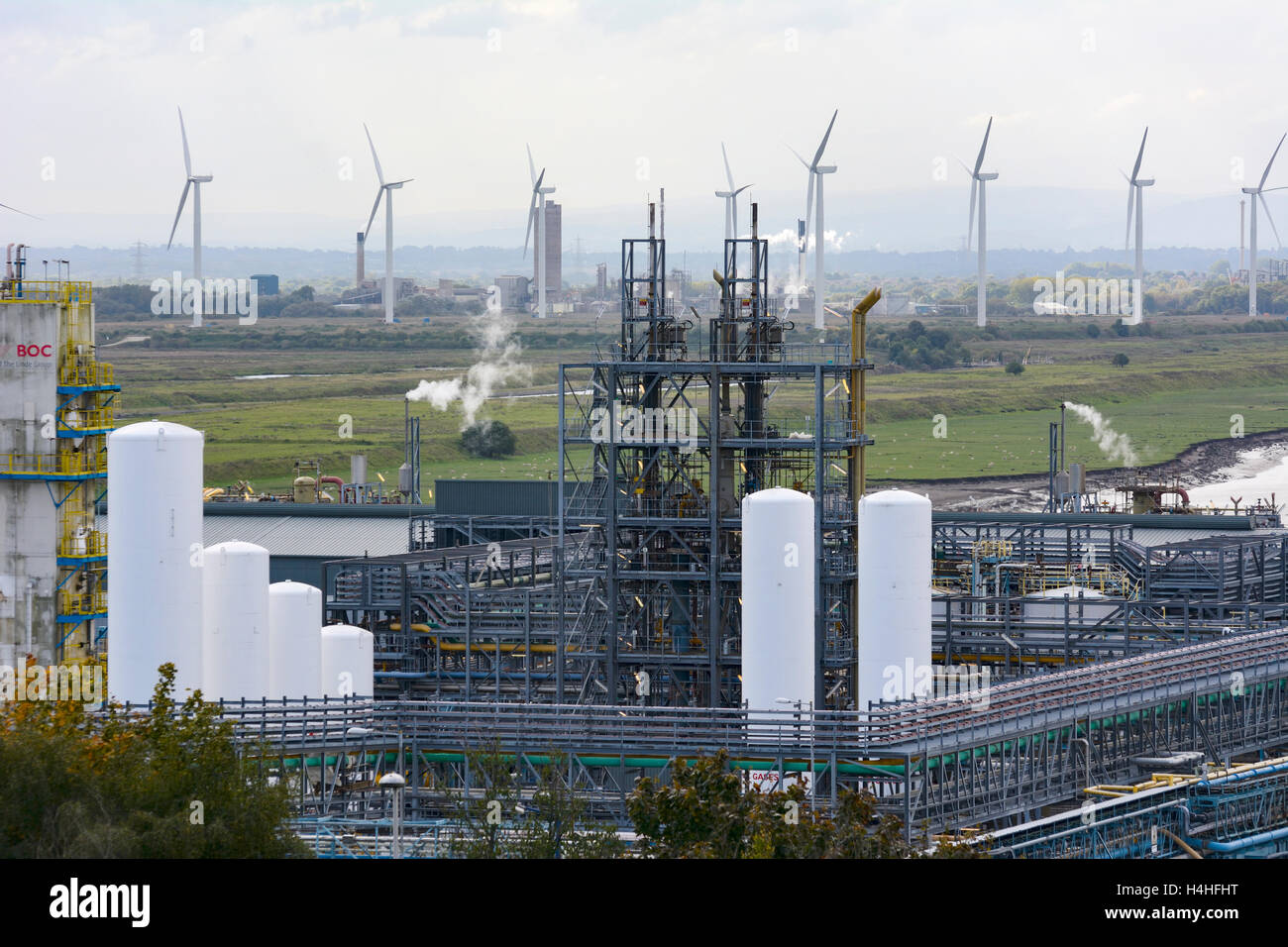 Ineos chemical plant at Weston Point, Runcorn, with the Frodsham wind farm on Frodsham Marshes in the background. Stock Photo