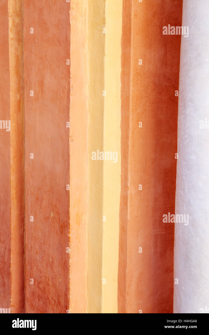 Multicolor vertical cornered section of a wall in the Reales Alcazares in Sevilla with a partial section of a marble column Stock Photo