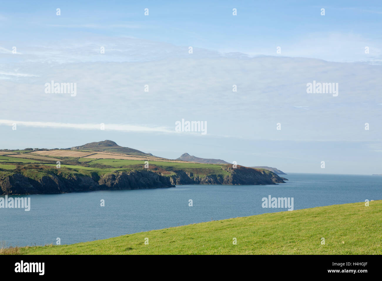 Rugged West Coast of the British Isles. Calm day with blue sky and sea with white streaks of cloud. Stock Photo