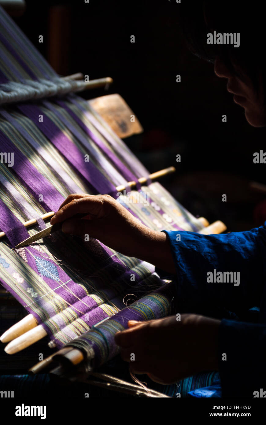 Detail of woman's hand weaving traditional textile on back-strap loom in Thimphu, Bhutan Stock Photo