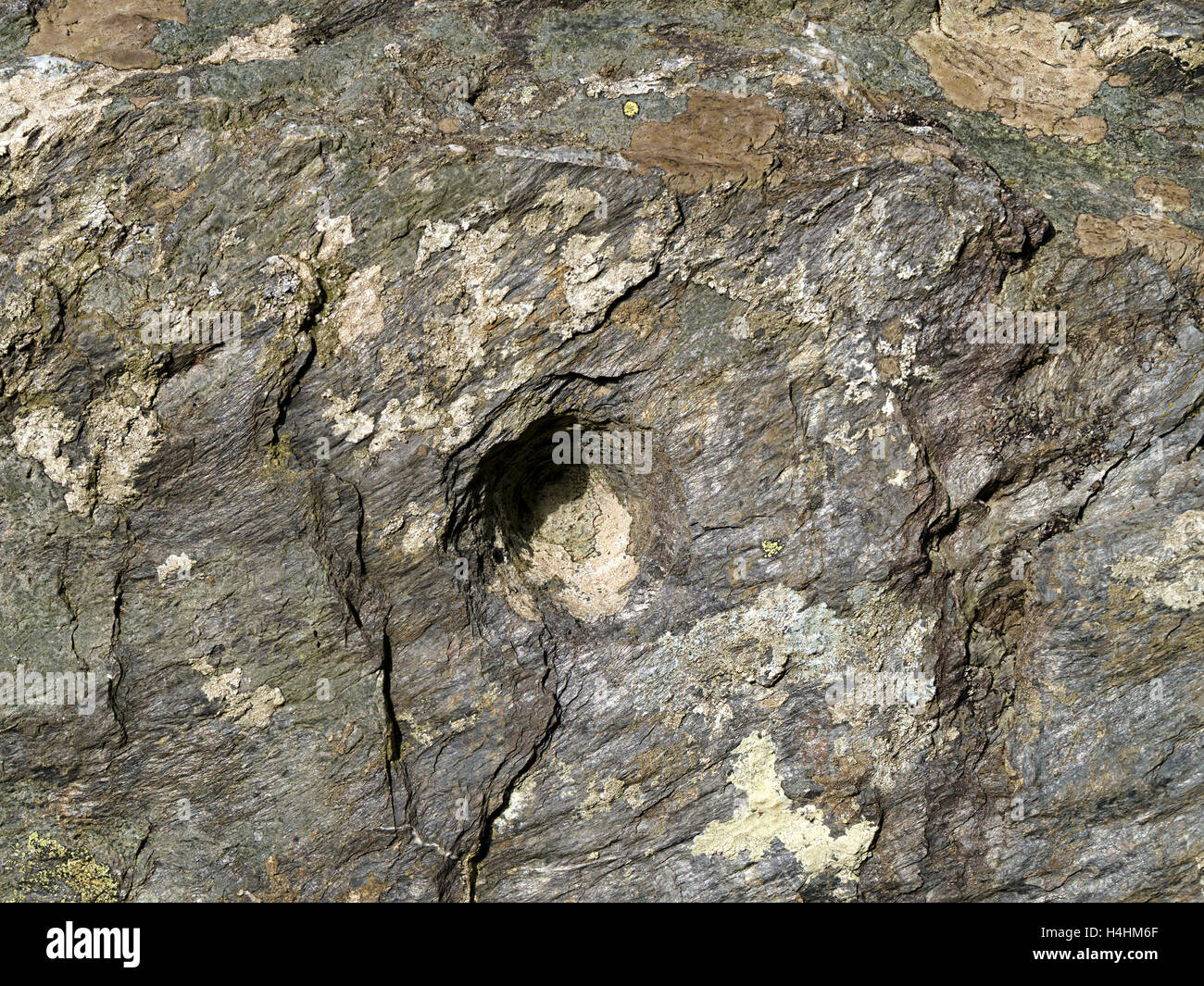 Ancient bronze age cup mark in rock by cave entrance, Kiloran, Isle of