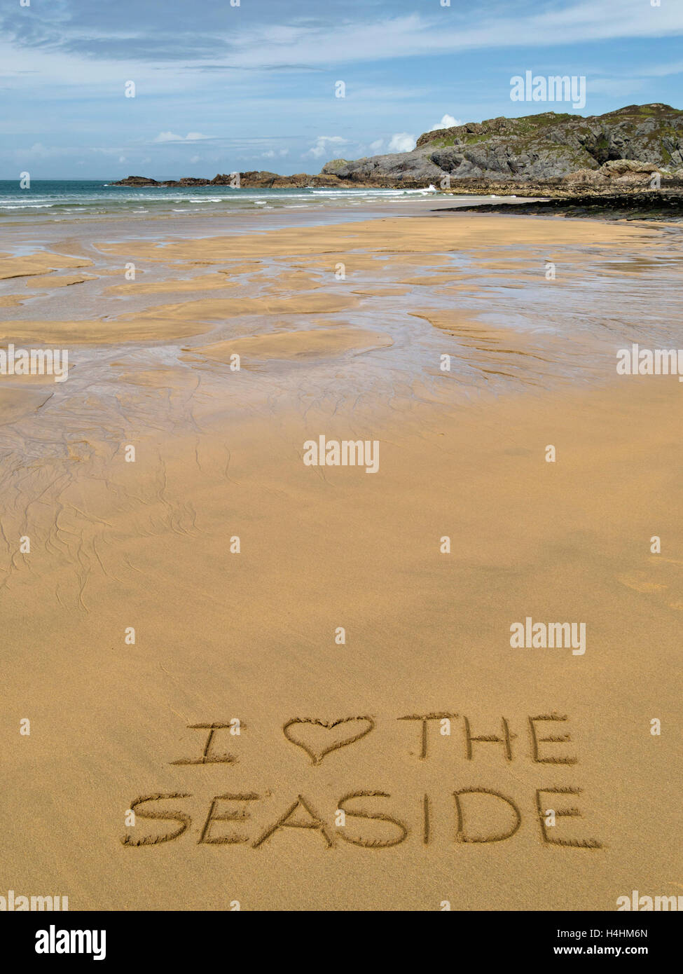 The words 'I love the seaside' written in golden yellow sand of remote Scottish beach. Stock Photo