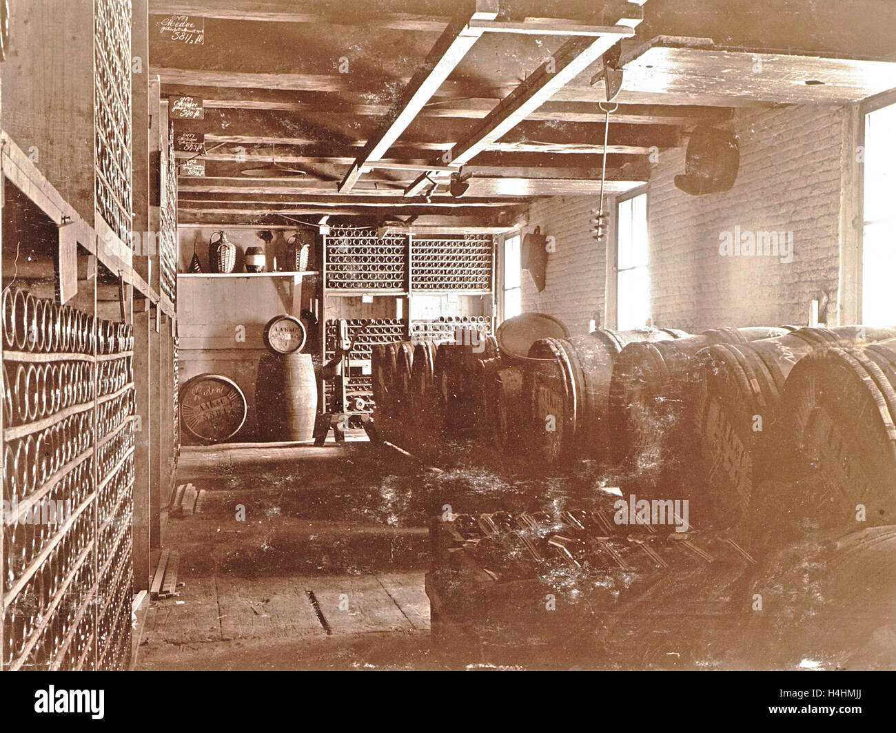 Interior of a brewery wooden barrels and bottles on shelves, Anonymous
