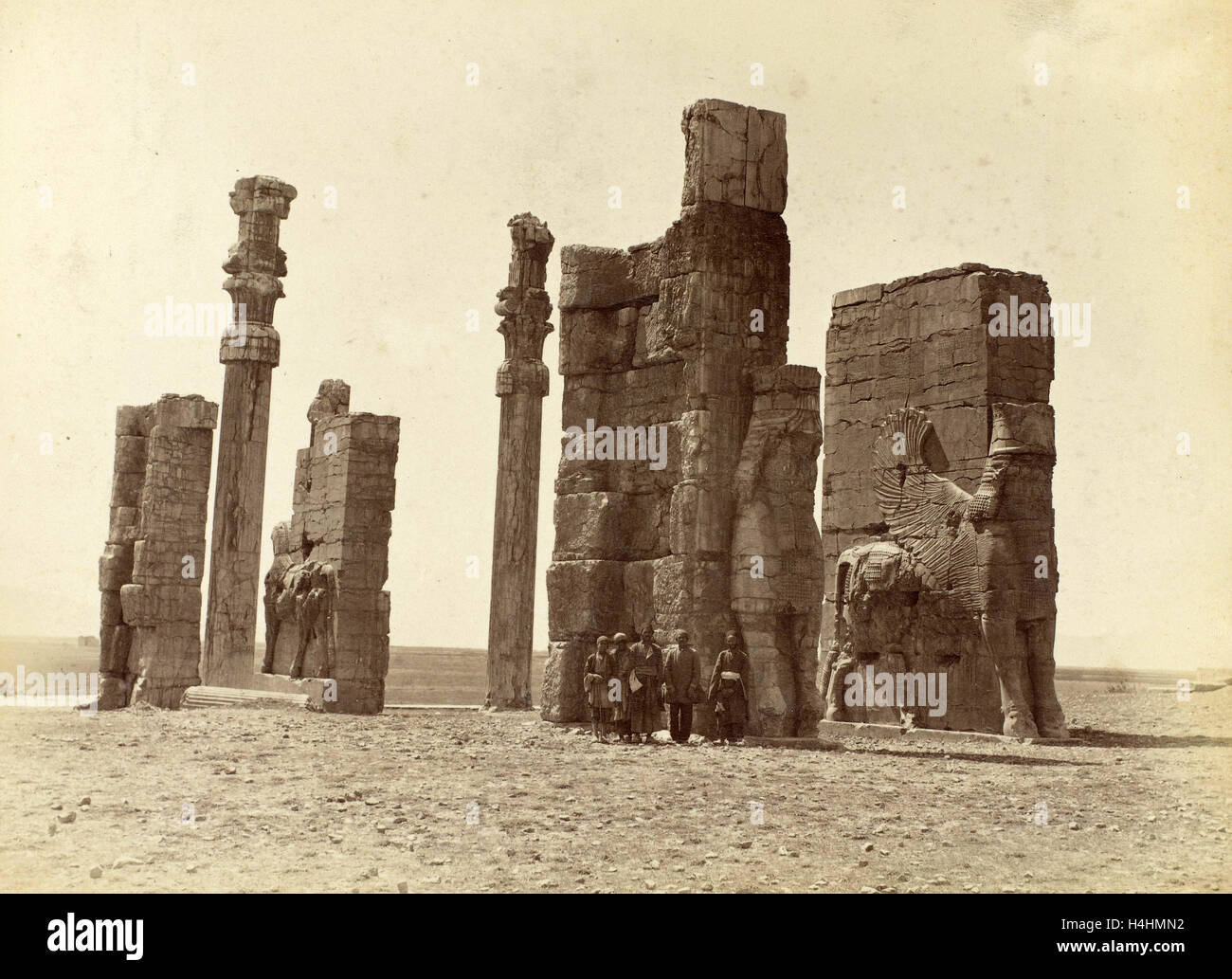 Group of men posing at the Gate of all Nations (Gate of Xerxes) at Persepolis Iran, Antoine Sevruguin attributed to Stock Photo
