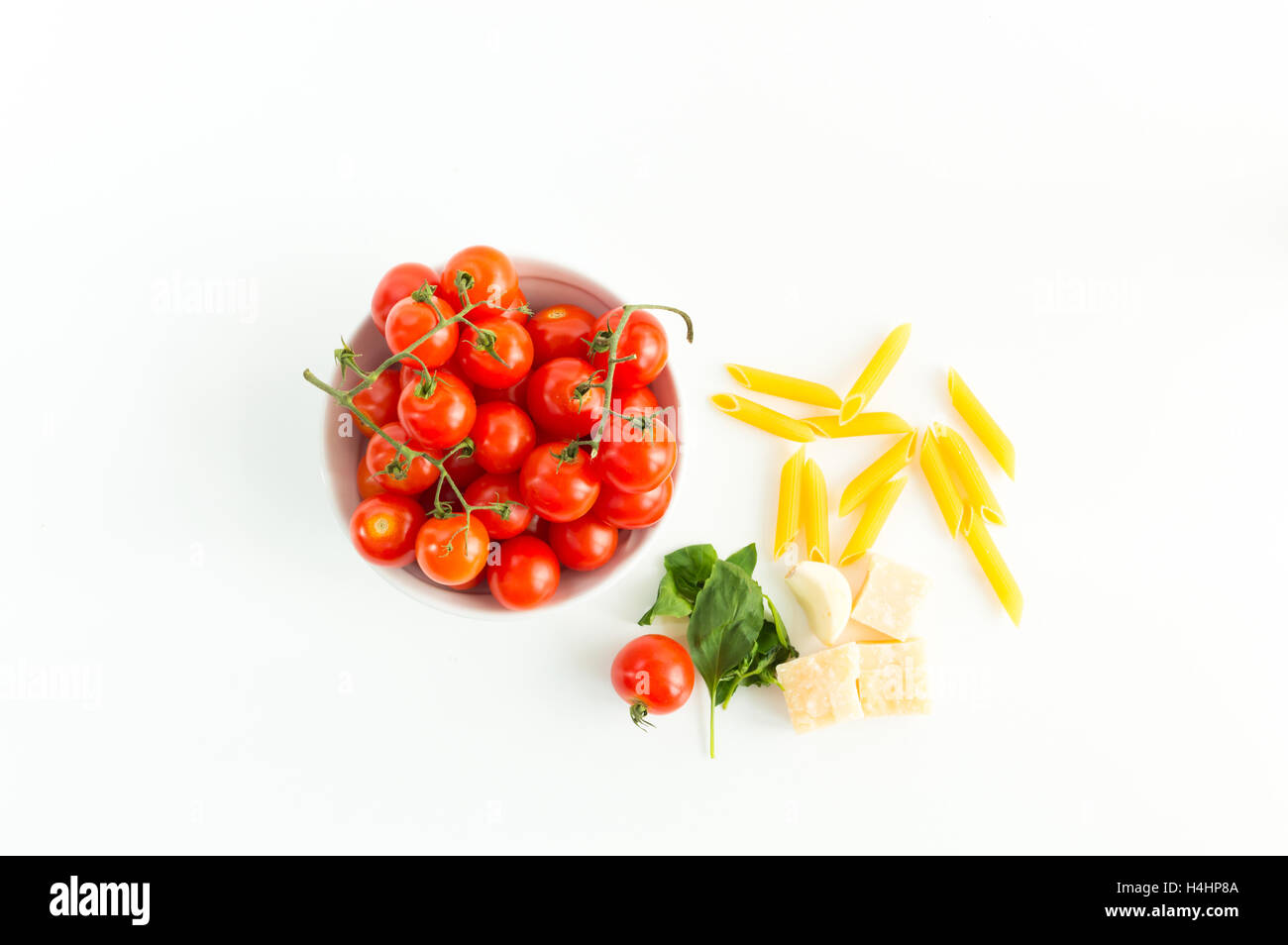 Italian red tomatoes close up food with pasta, basil leafs, cheese, isolated on white background - Top view Stock Photo