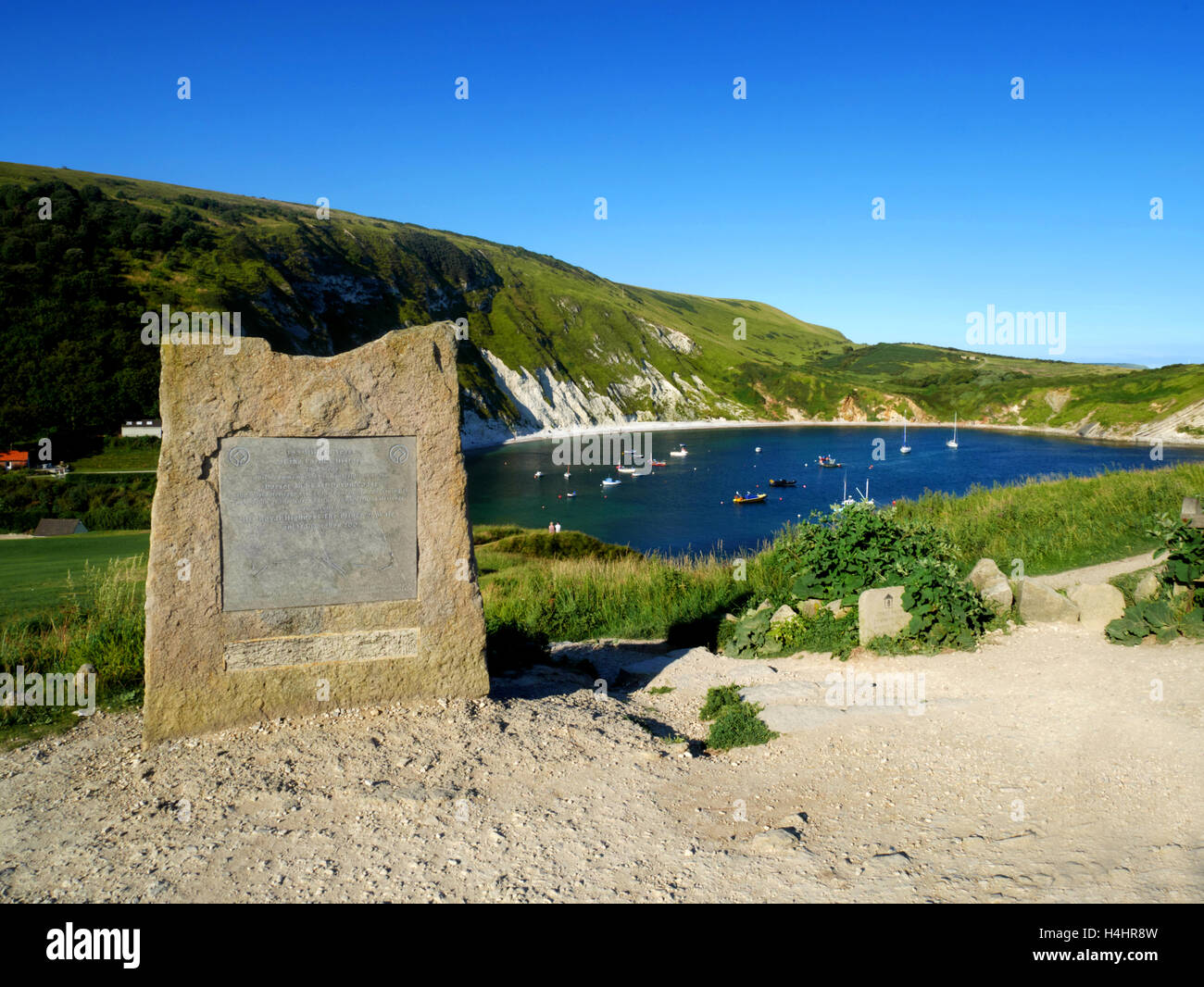 This stone marks the designation of the Jurassic Coast as a UNESCO World Heritage site in 2002, at Lulworth Cove, Dorset. Stock Photo