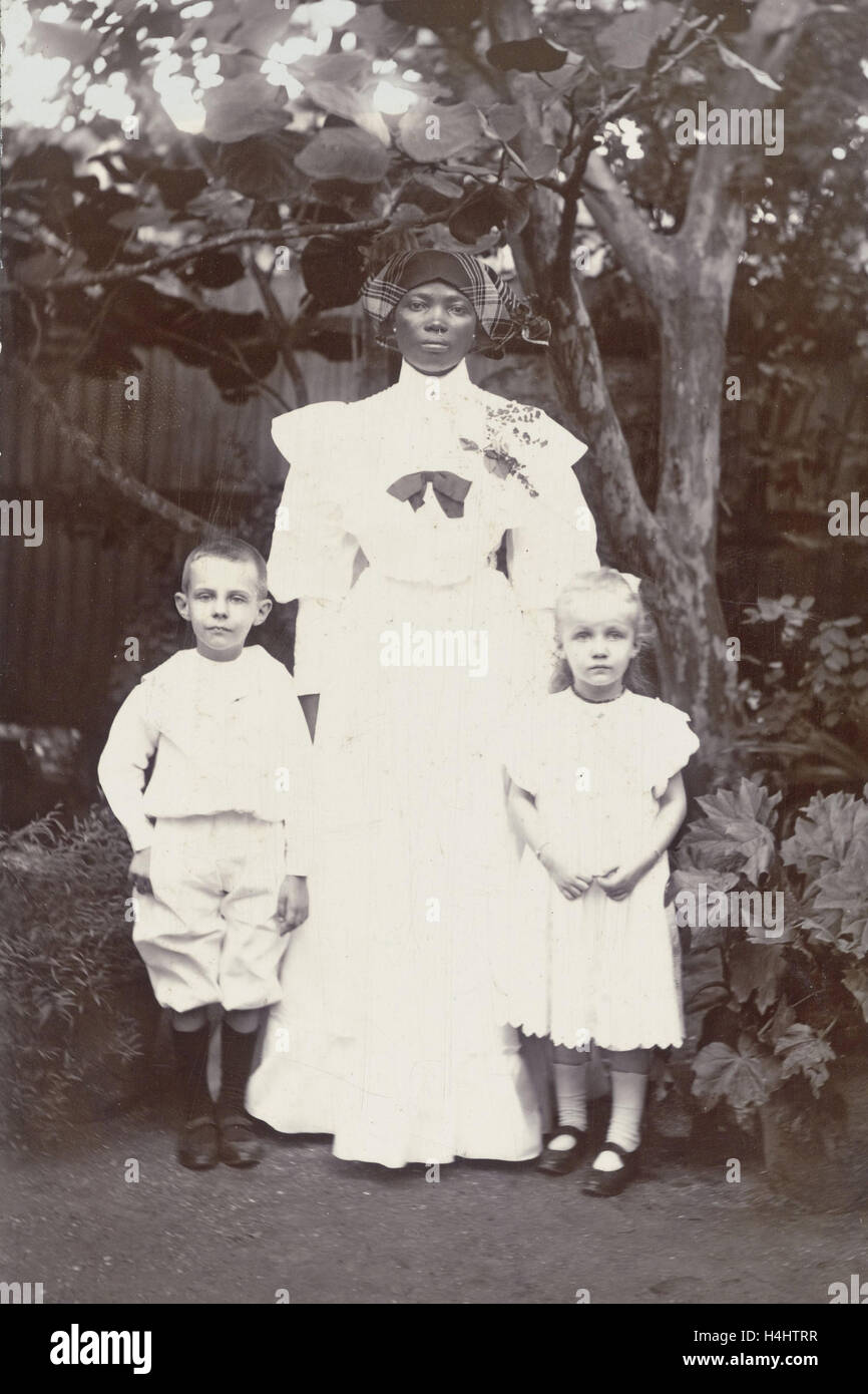 Portrait of Surinamese nanny with two white children, Augusta Curiel, 1906 Stock Photo