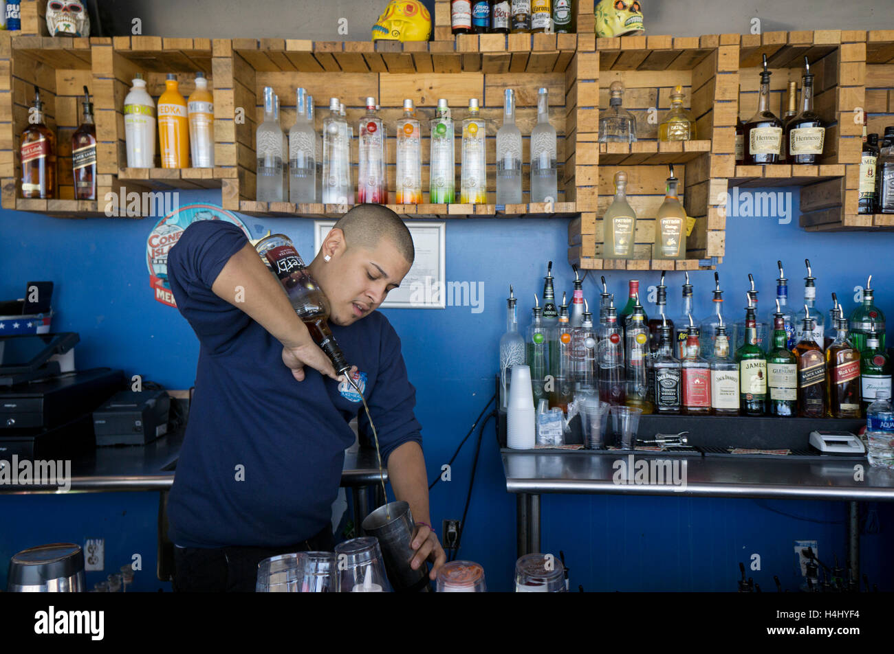 A juggling bartender pouring a drink while balanced a bottle of liquor