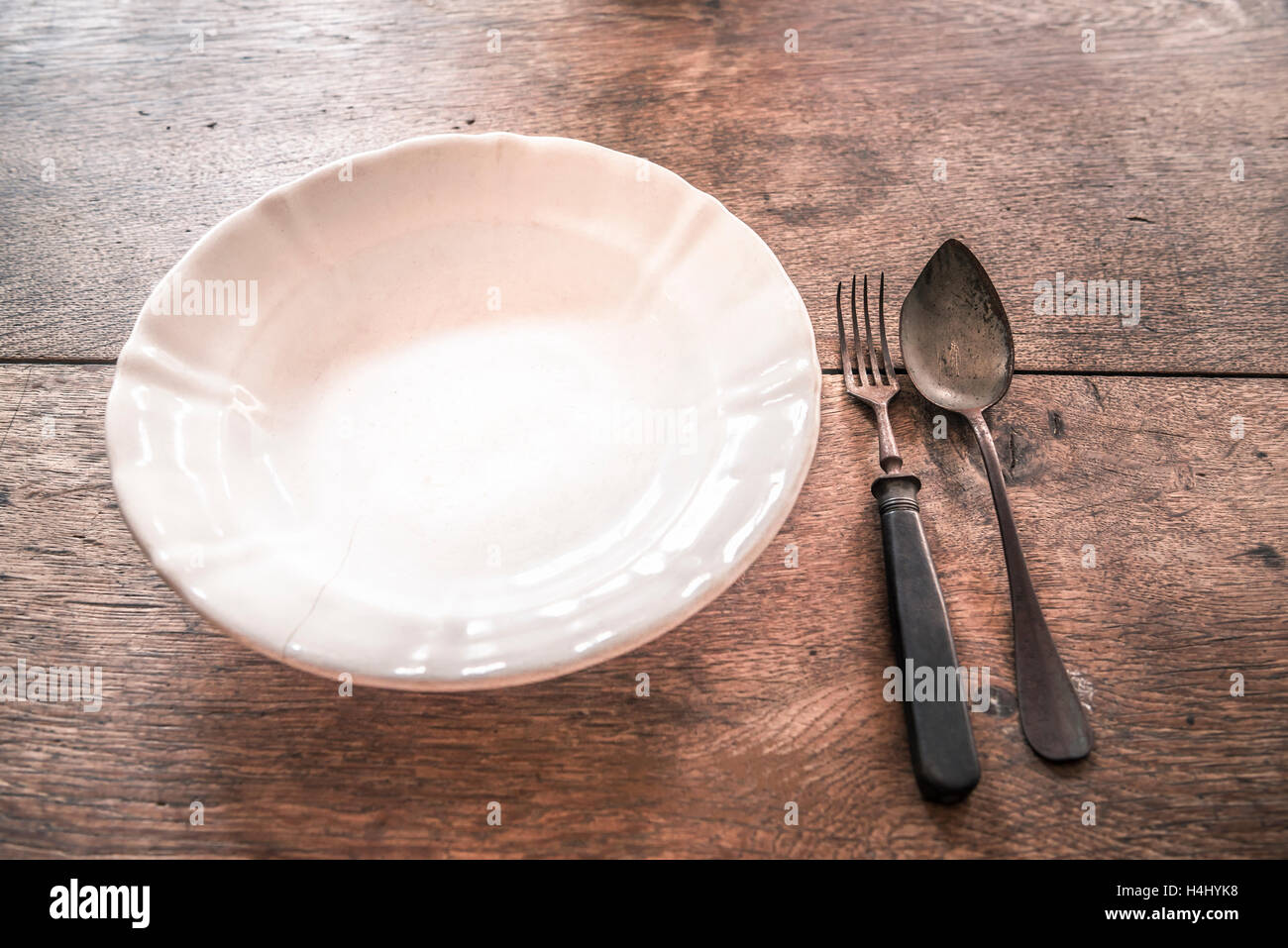 Rustic weathered tableware on wooden table Stock Photo
