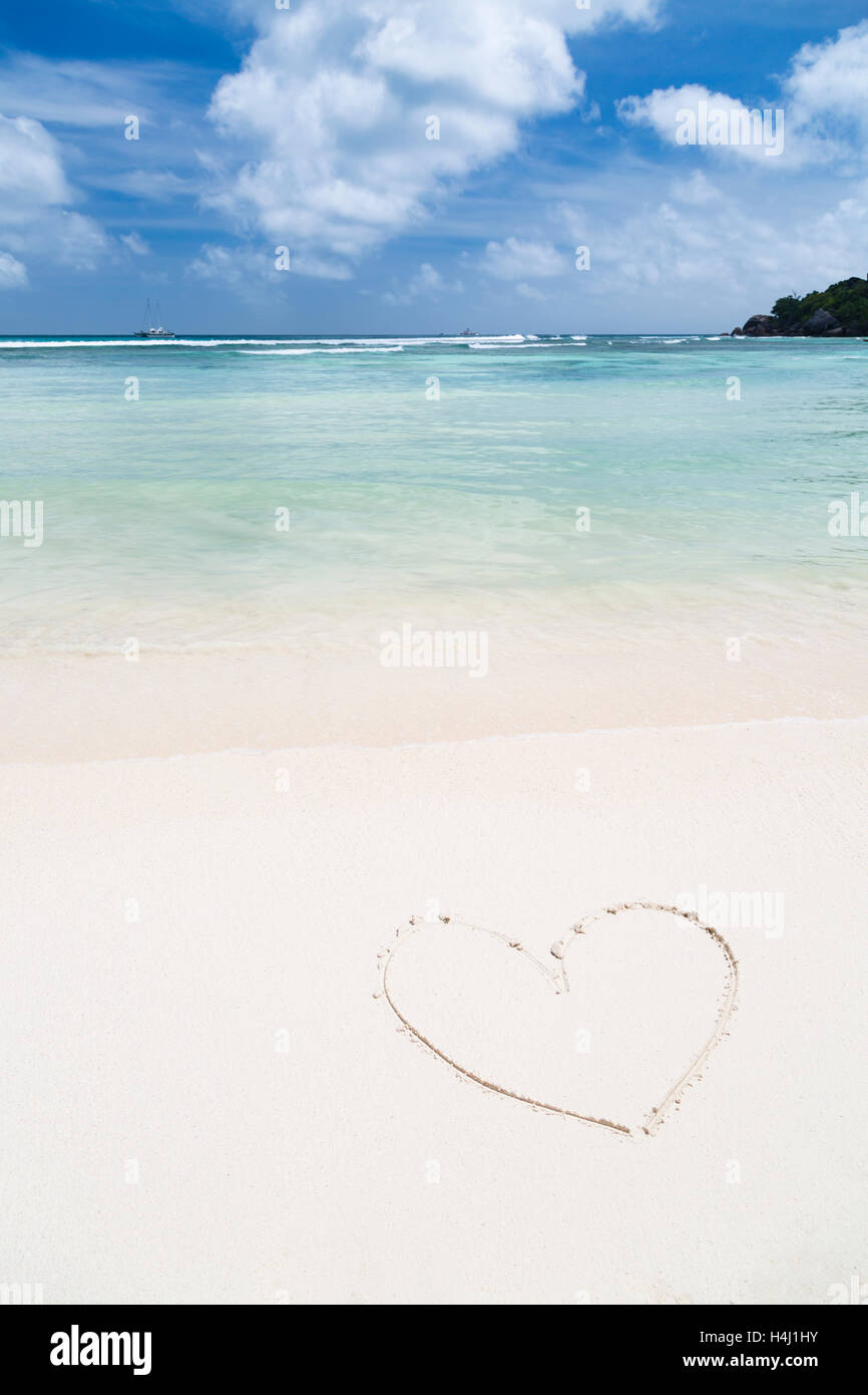 Heart shape in the sand of a clean white beach with turquoise water Stock Photo