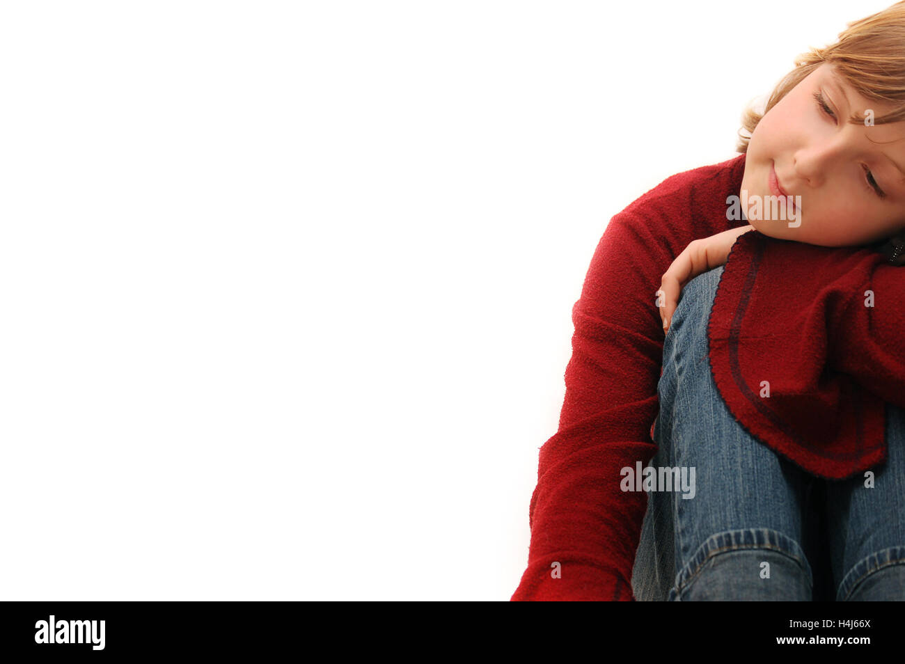 blond kid sitting and daydreaming Stock Photo