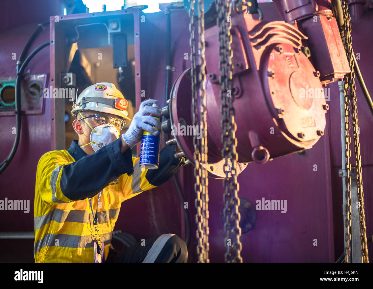 Industrial worker doing maintenance on machinery equipments Stock Photo