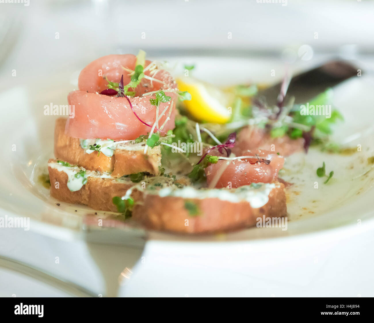 Smoked salmon with garlic cream sauce crostini starter dish Stock Photo